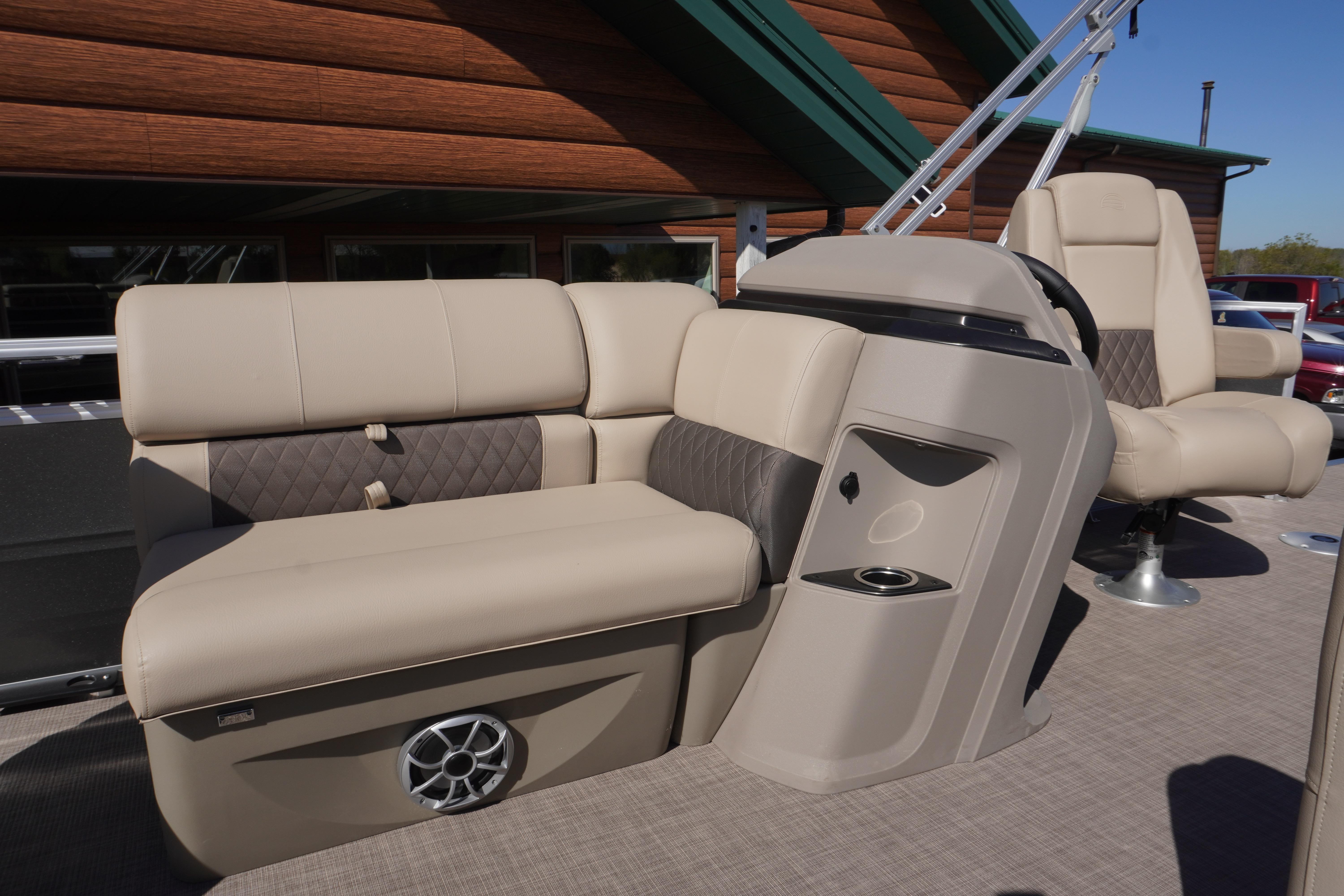 2024 Sun Tracker Fishin' Barge 20 DLX interior with beige seating and console.
