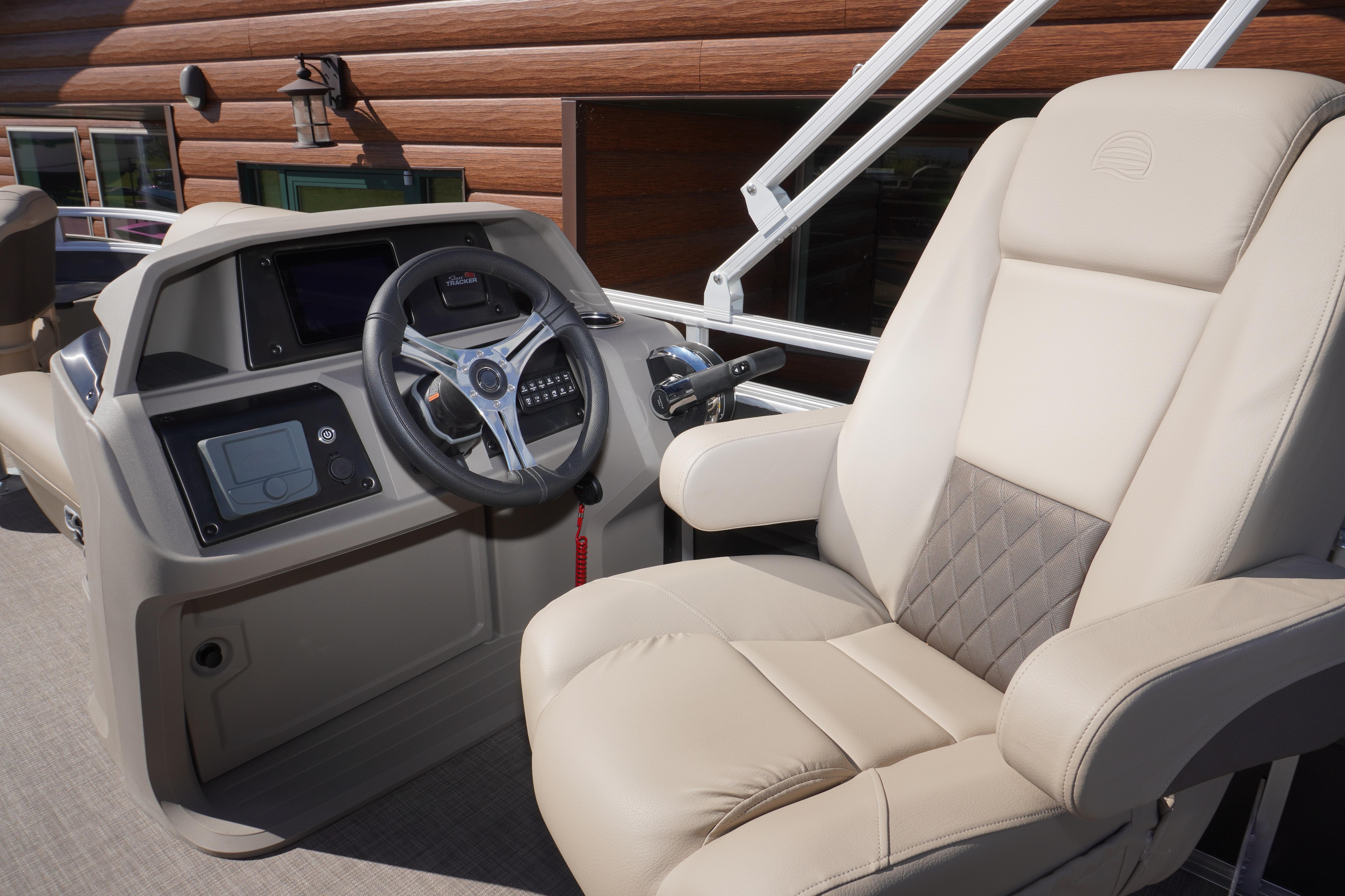 2024 Sun Tracker Fishin' Barge 20 DLX helm with plush captain's chair and modern controls.