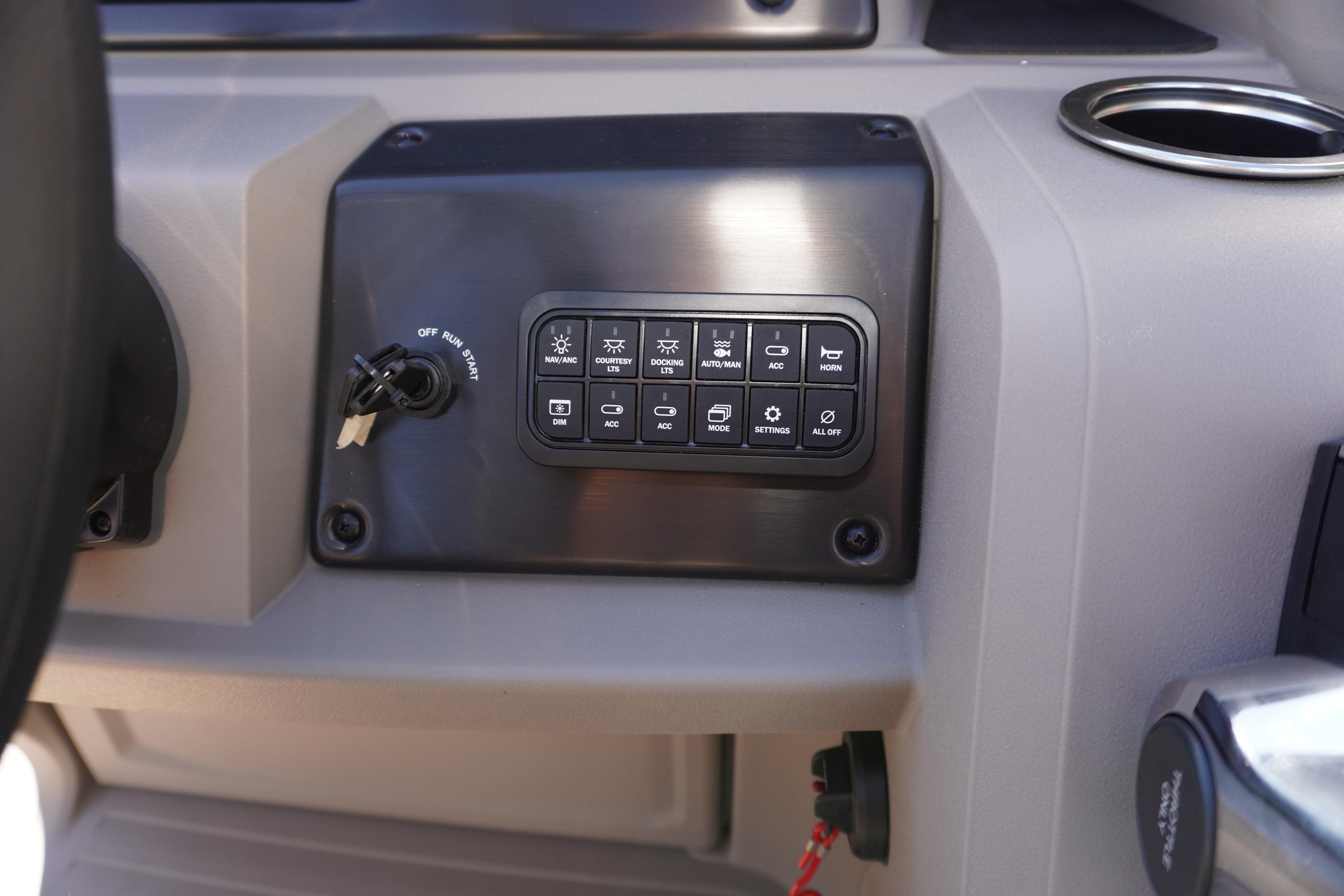 Control panel of 2024 Sun Tracker Fishin' Barge 20 DLX with ignition switch and buttons.