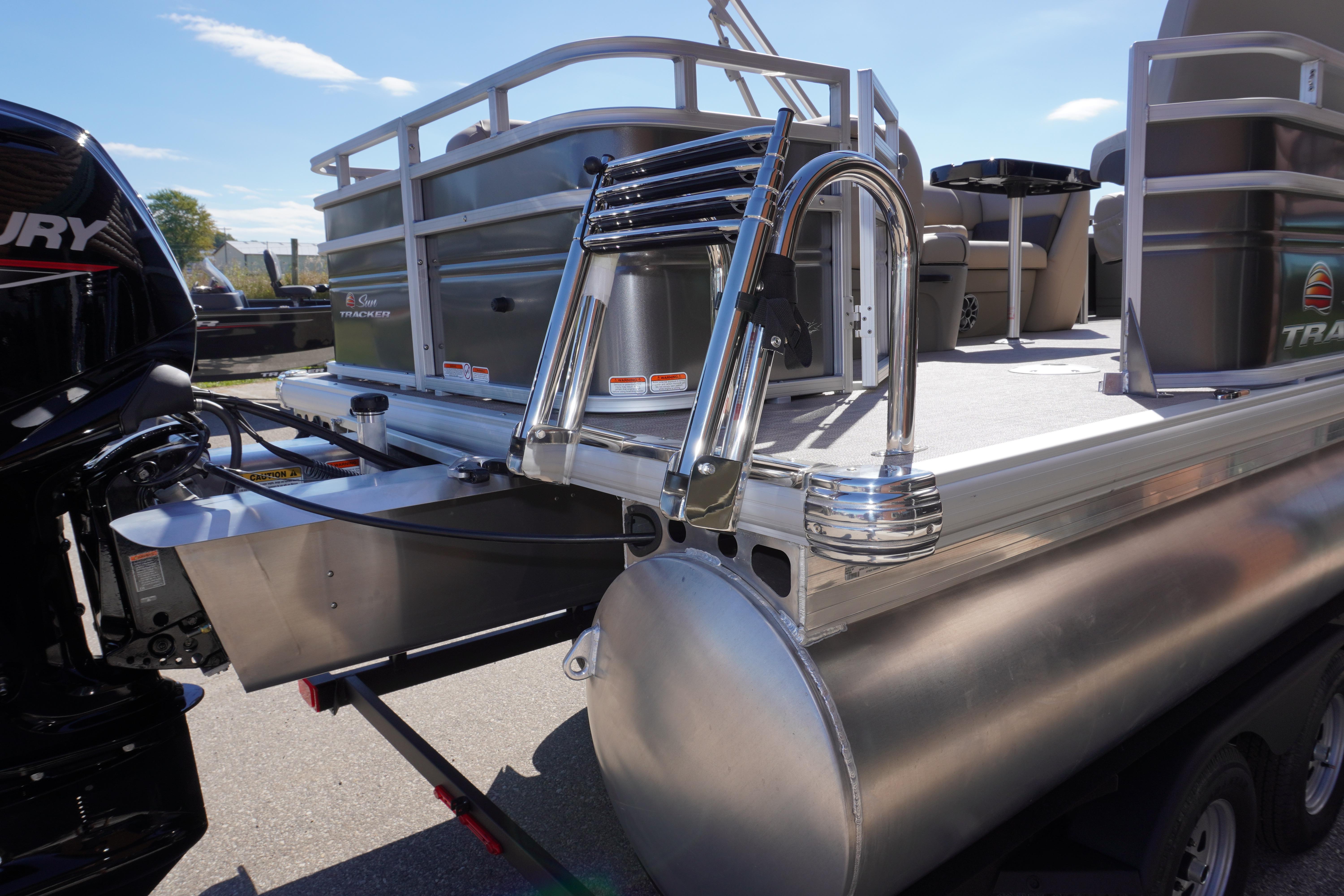 2024 Sun Tracker Fishin' Barge 20 DLX pontoon boat with ladder and outboard motor.