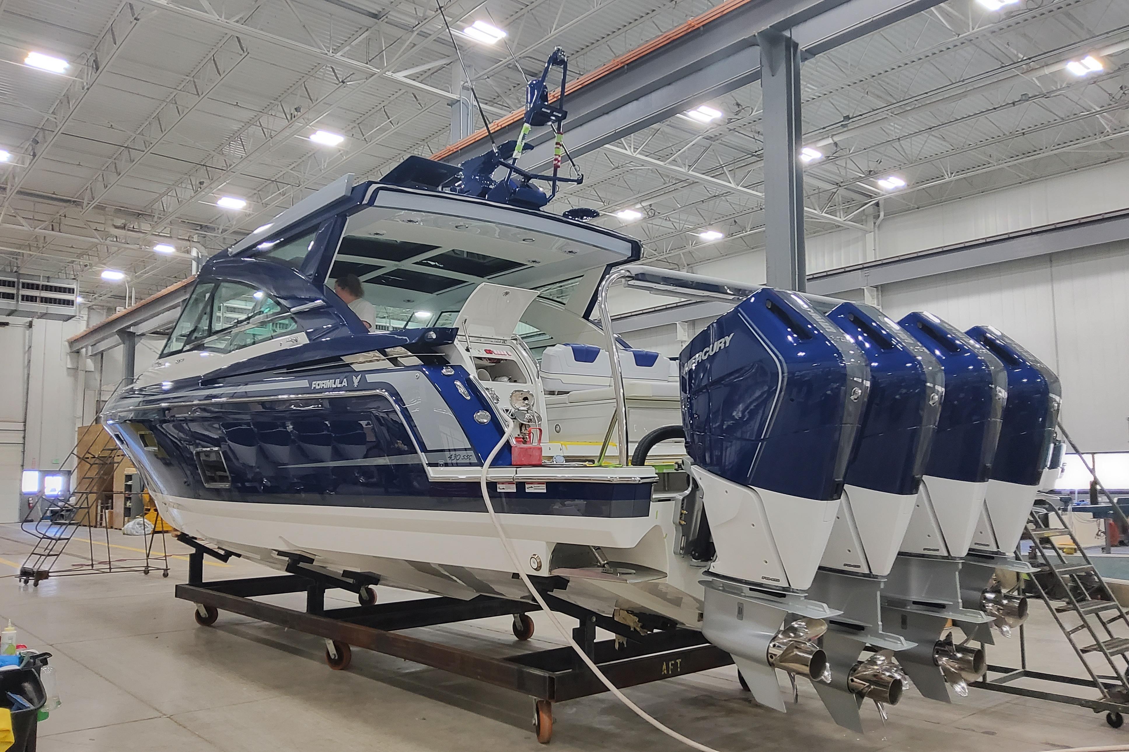 2026 Formula 430 Super Sport Crossover boat with four engines in a warehouse setting.