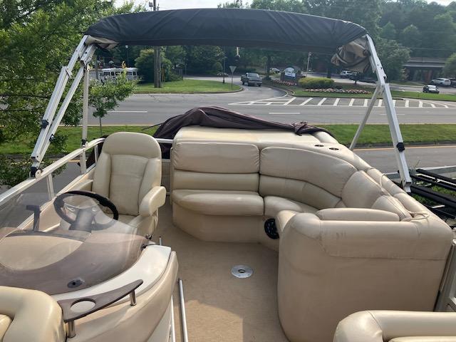 2007 Bennington 2275QXi pontoon boat with beige seating and canopy, parked near a road.