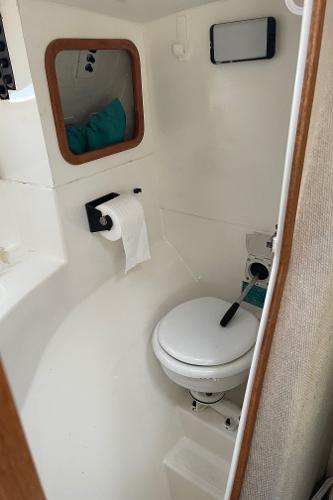 Compact bathroom in 1996 Corsair F-31 sailboat with toilet and storage.