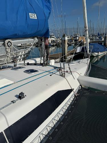 1996 Corsair F-31 sailboat docked in marina, featuring blue sail cover and rigging.