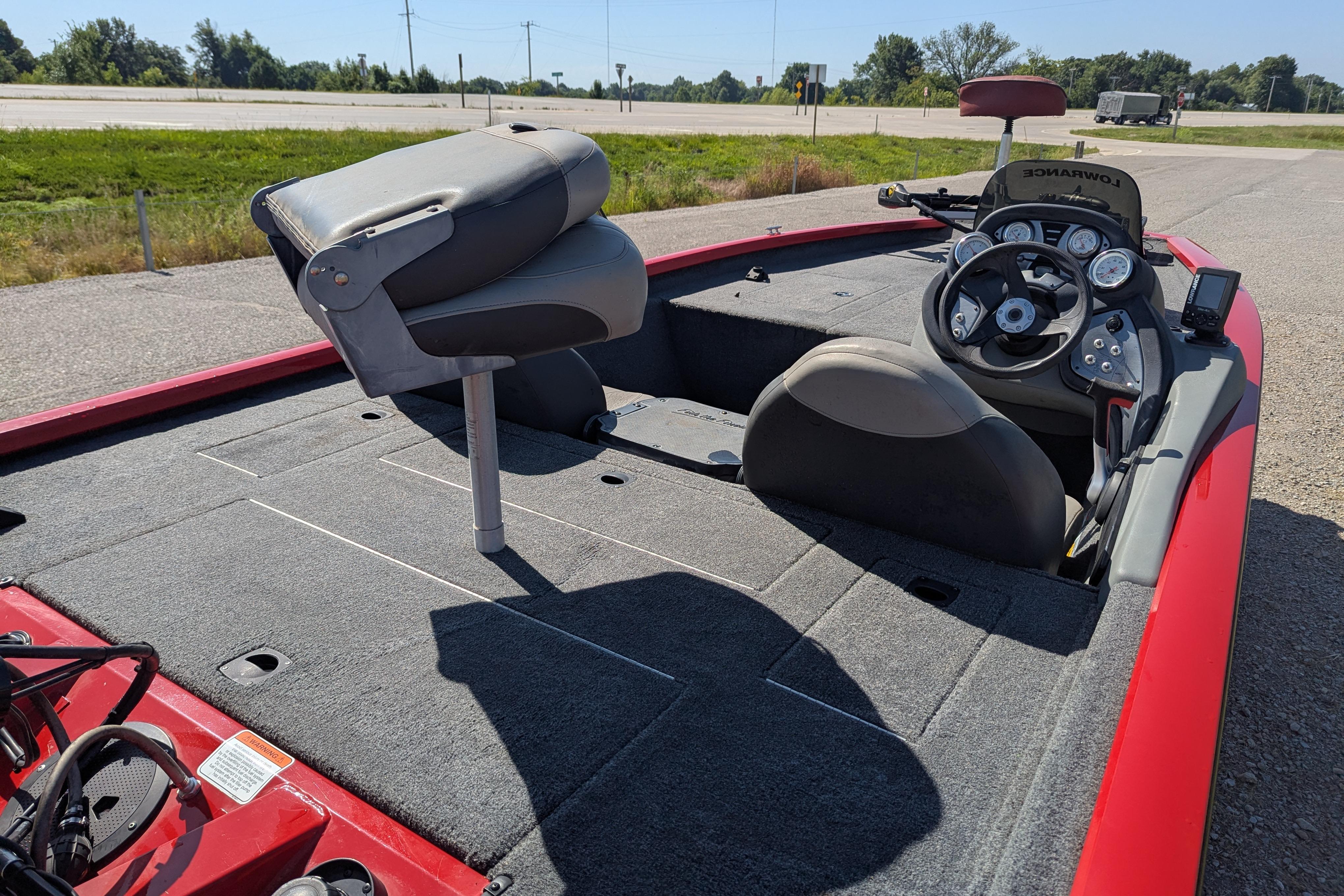 2015 Tracker Pro Team 175 TXW fishing boat with steering console and seating, parked on roadside.