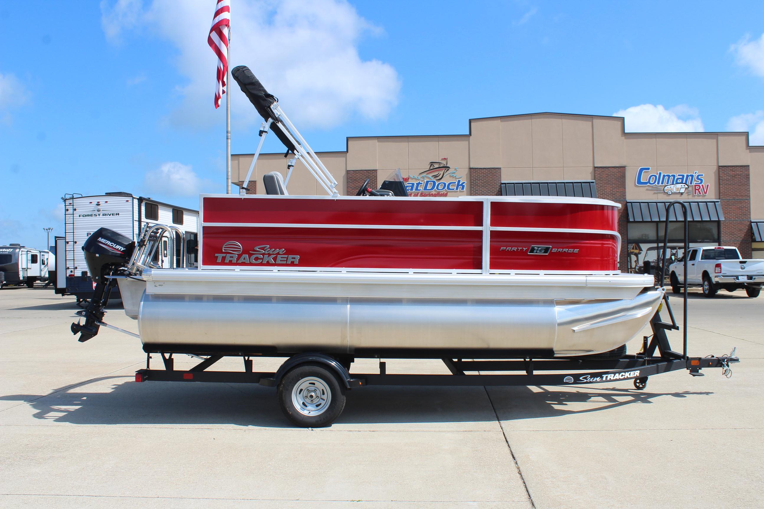 2026 Sun Tracker Party Barge 16 DLX pontoon boat on trailer, parked at dealership.