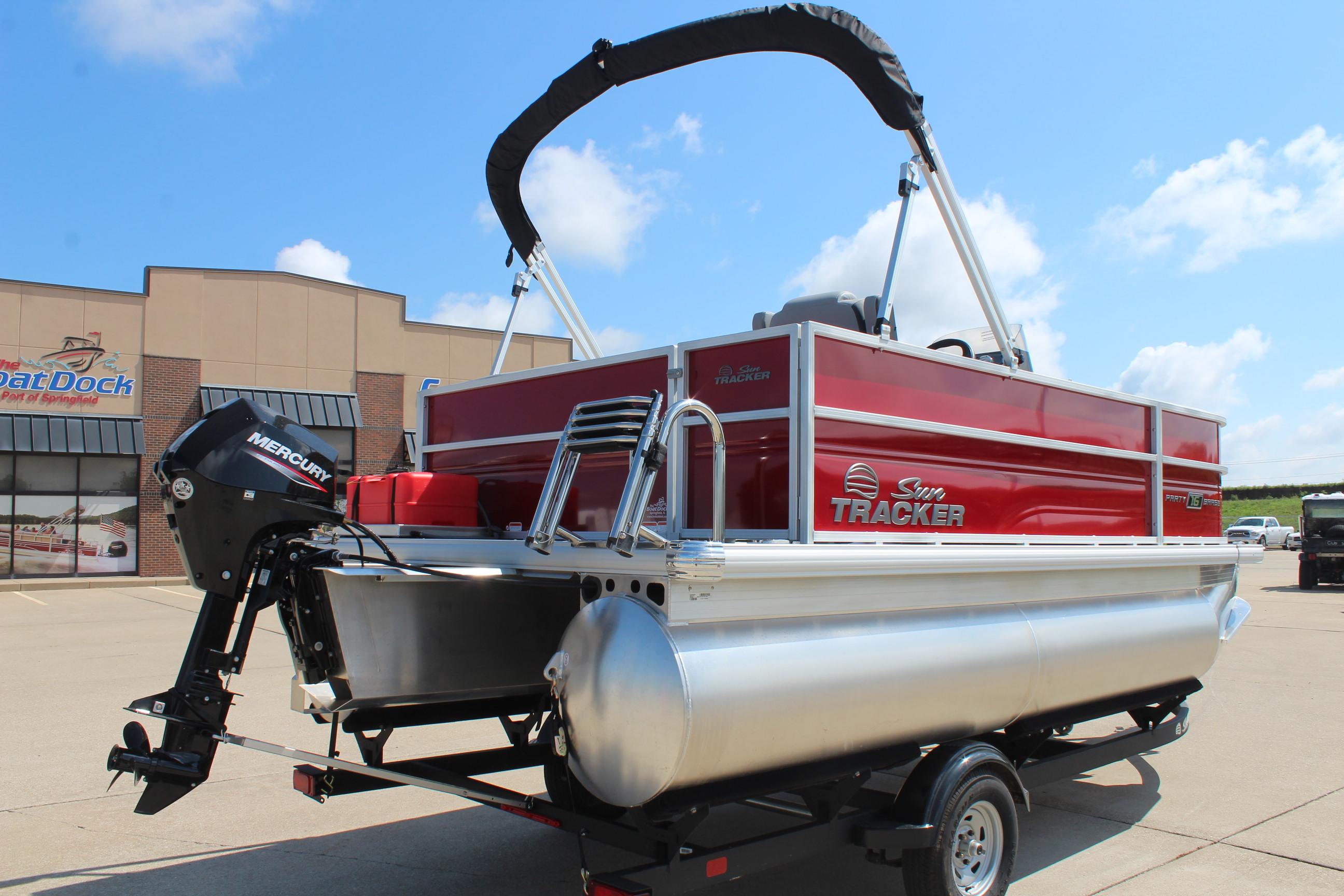 2026 Sun Tracker Party Barge 16 DLX pontoon boat with Mercury engine, parked outdoors.