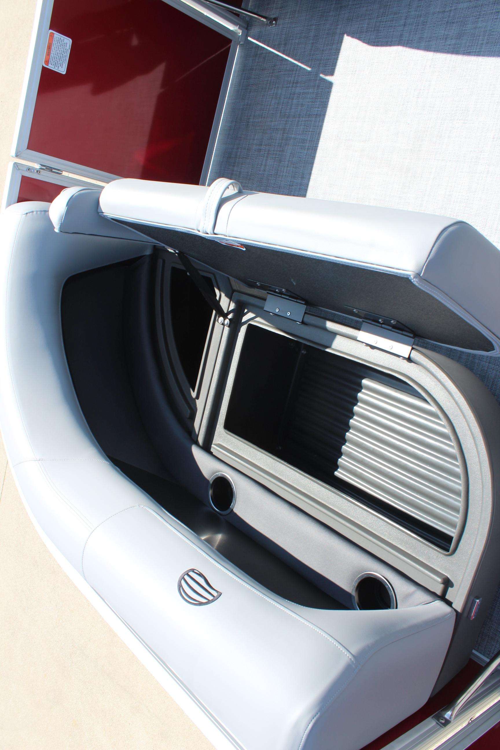 2026 Sun Tracker Party Barge 16 DLX seat storage with cup holders and open compartment.