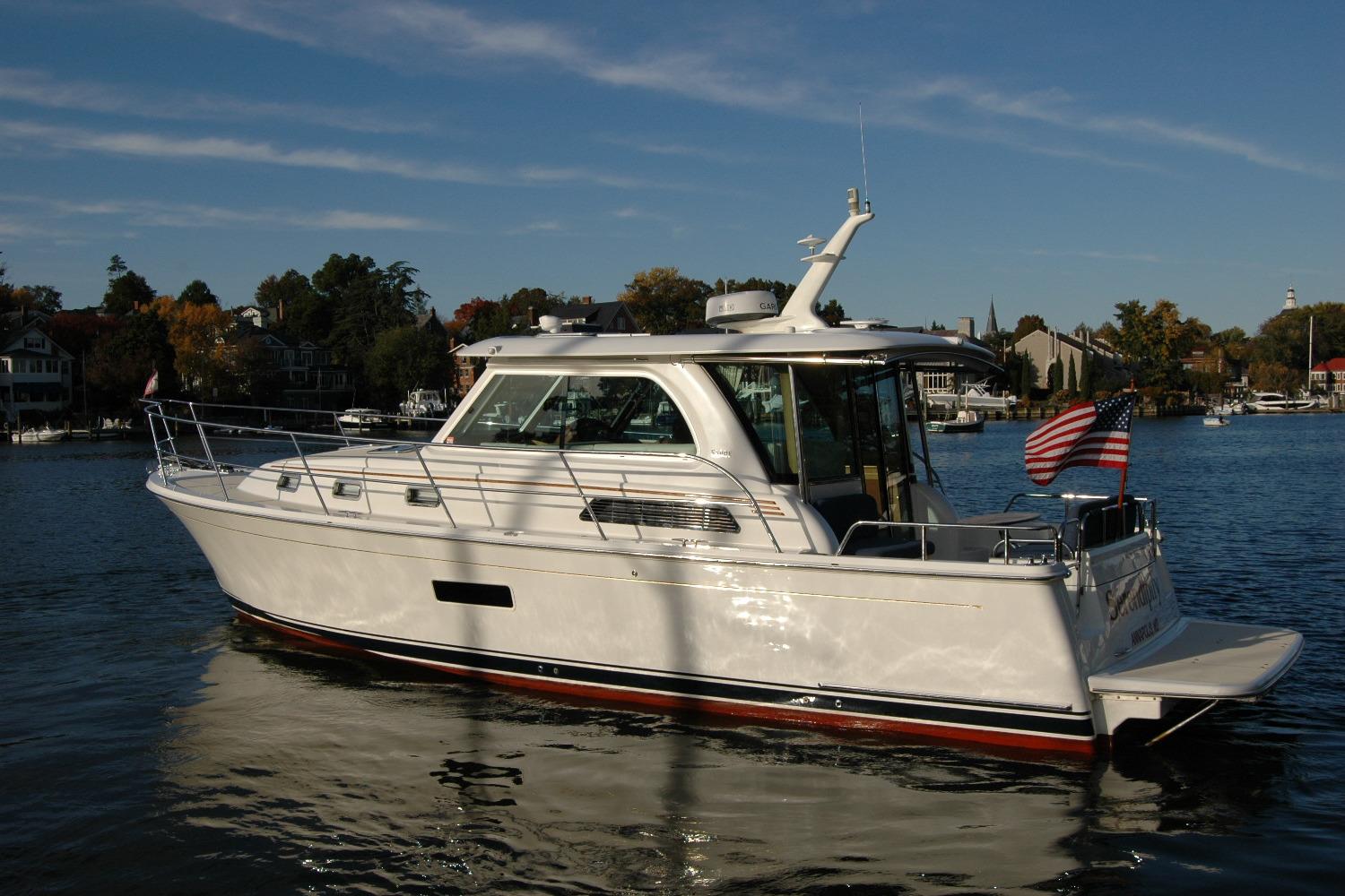 2019 Sabre 38 Salon Express yacht on a serene lake with American flag.