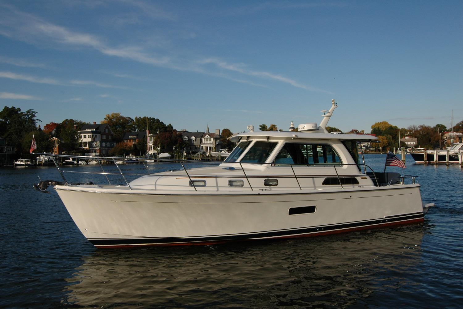 2019 Sabre 38 Salon Express yacht cruising on a scenic waterfront.