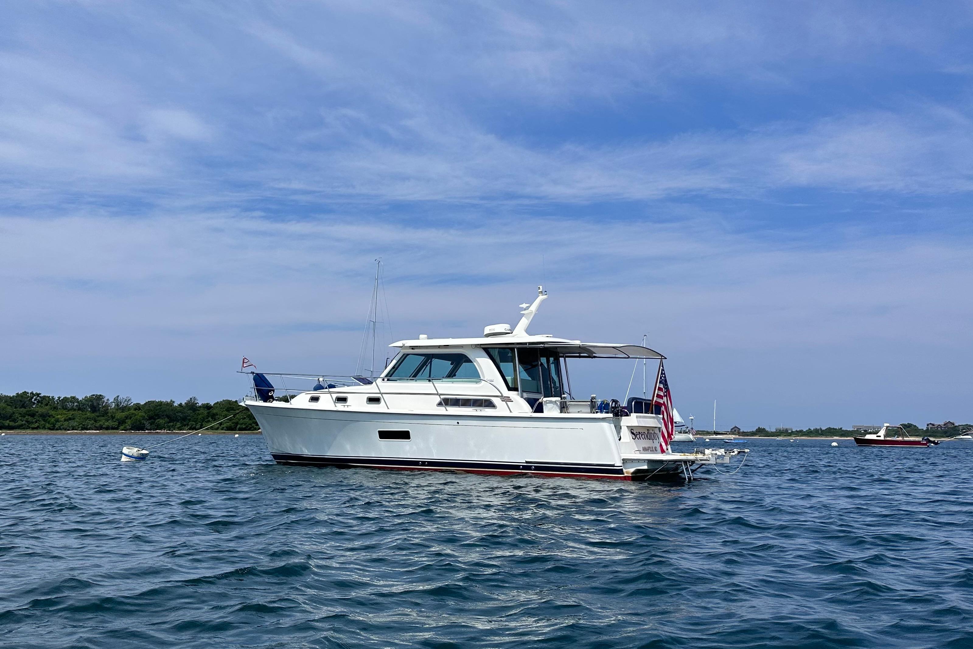 2019 Sabre 38 Salon Express yacht on calm water under blue sky.