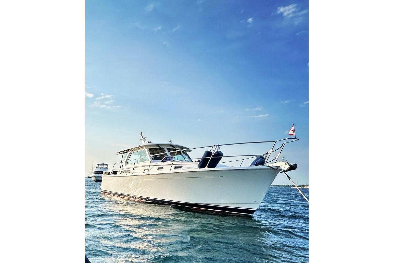 2019 Sabre 38 Salon Express yacht on calm water under clear blue sky.
