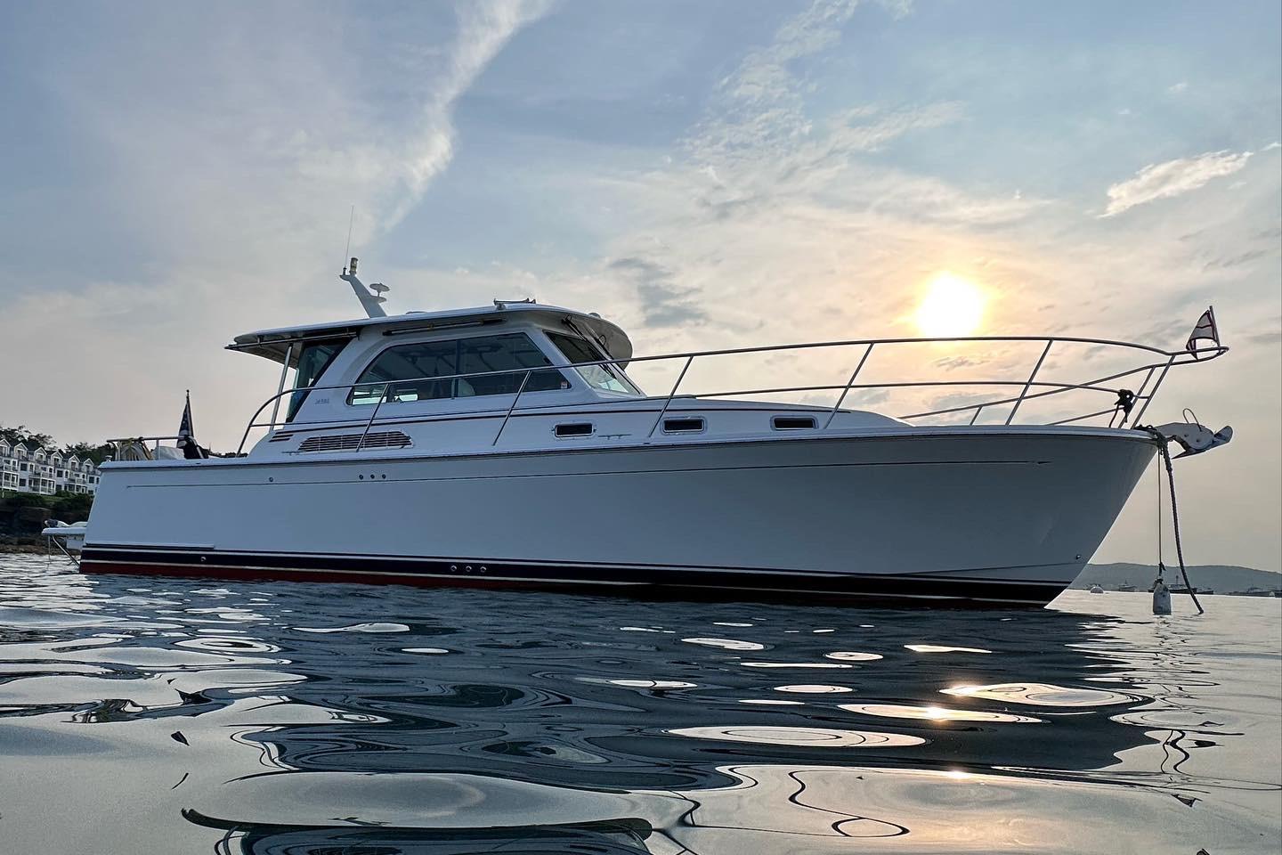 2019 Sabre 38 Salon Express yacht on calm water at sunset.