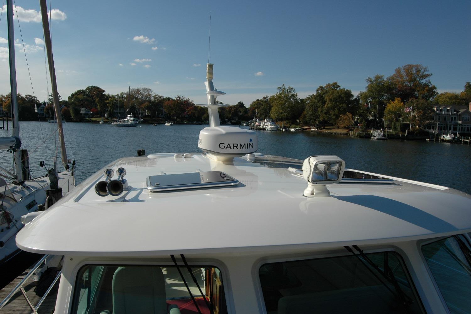 2019 Sabre 38 Salon Express yacht with Garmin equipment, docked by a scenic waterfront.