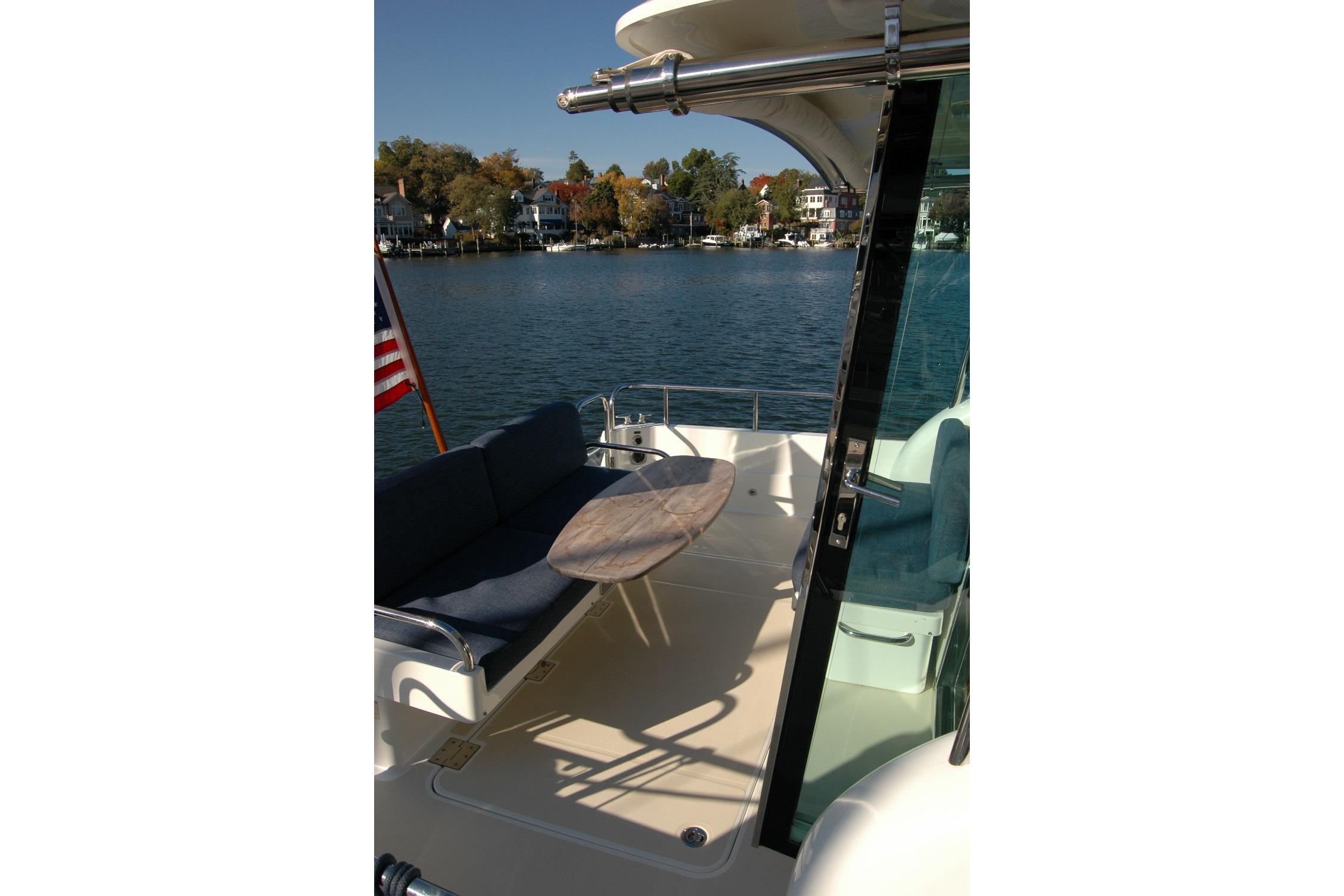 2019 Sabre 38 Salon Express yacht deck with seating and table, overlooking serene waterfront.