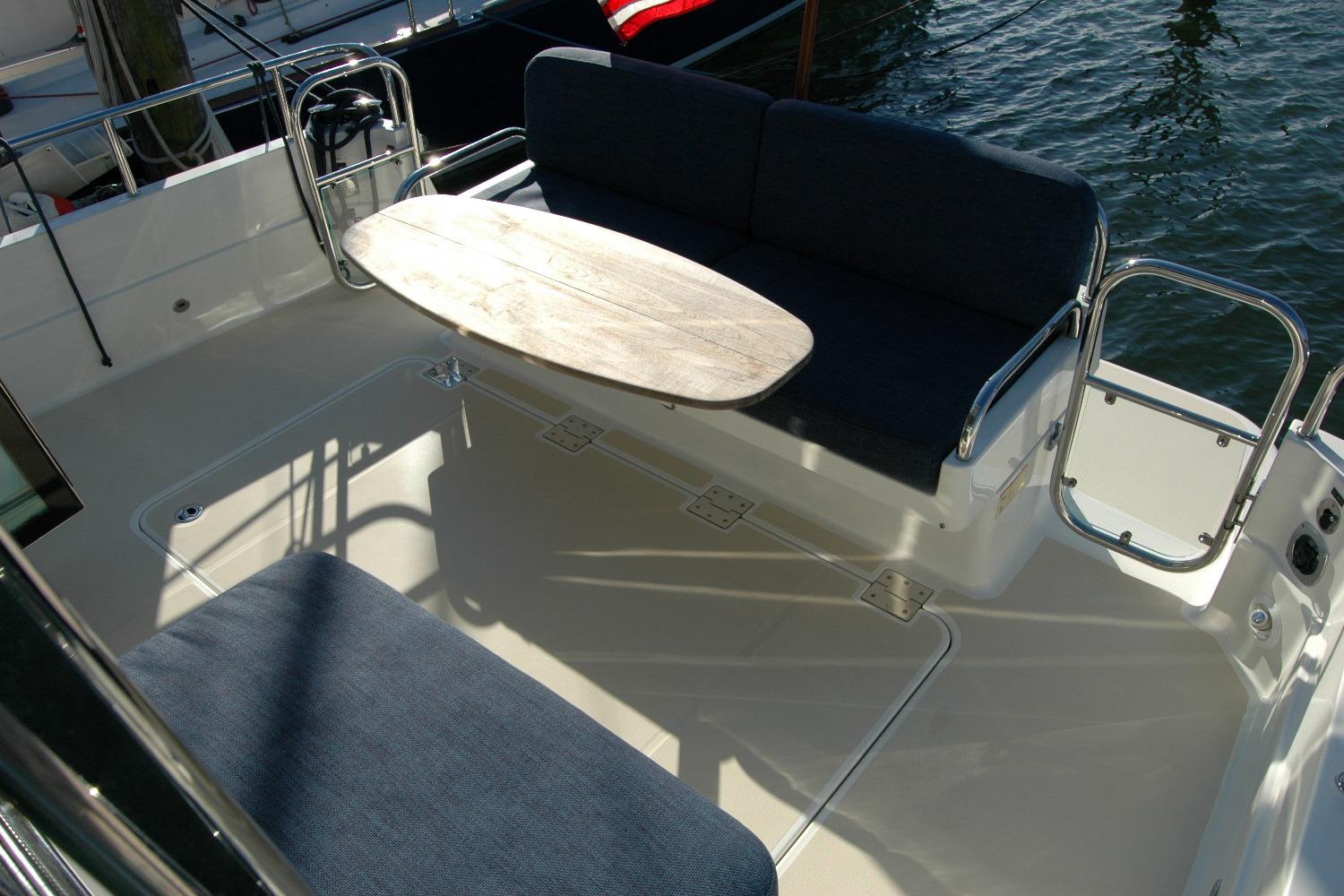 2019 Sabre 38 Salon Express deck with seating and table, docked by water.