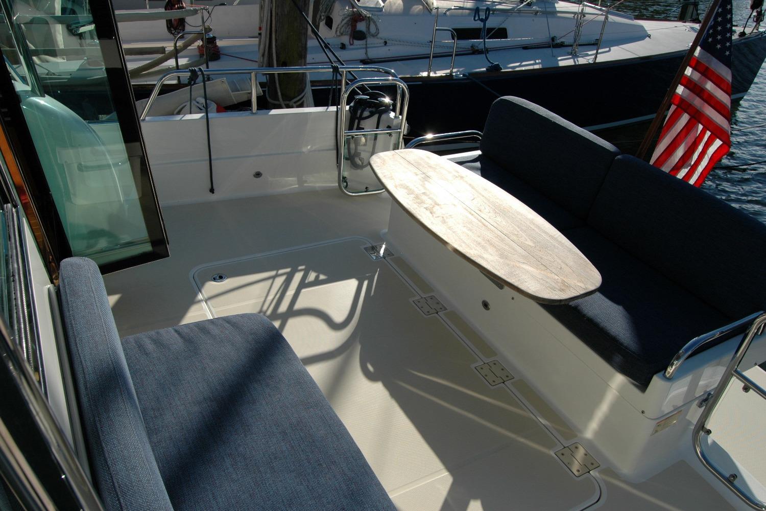 2019 Sabre 38 Salon Express yacht deck with seating and table, American flag visible.