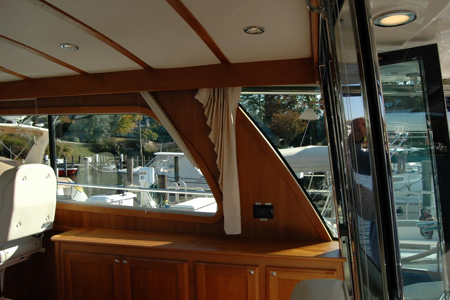 Interior view of 2019 Sabre 38 Salon Express yacht with wooden cabinetry and marina backdrop.