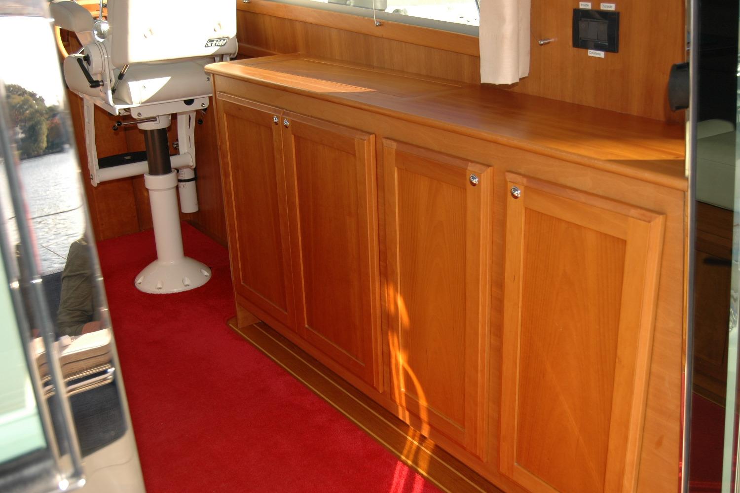 Interior of 2019 Sabre 38 Salon Express with wooden cabinetry and red carpet.