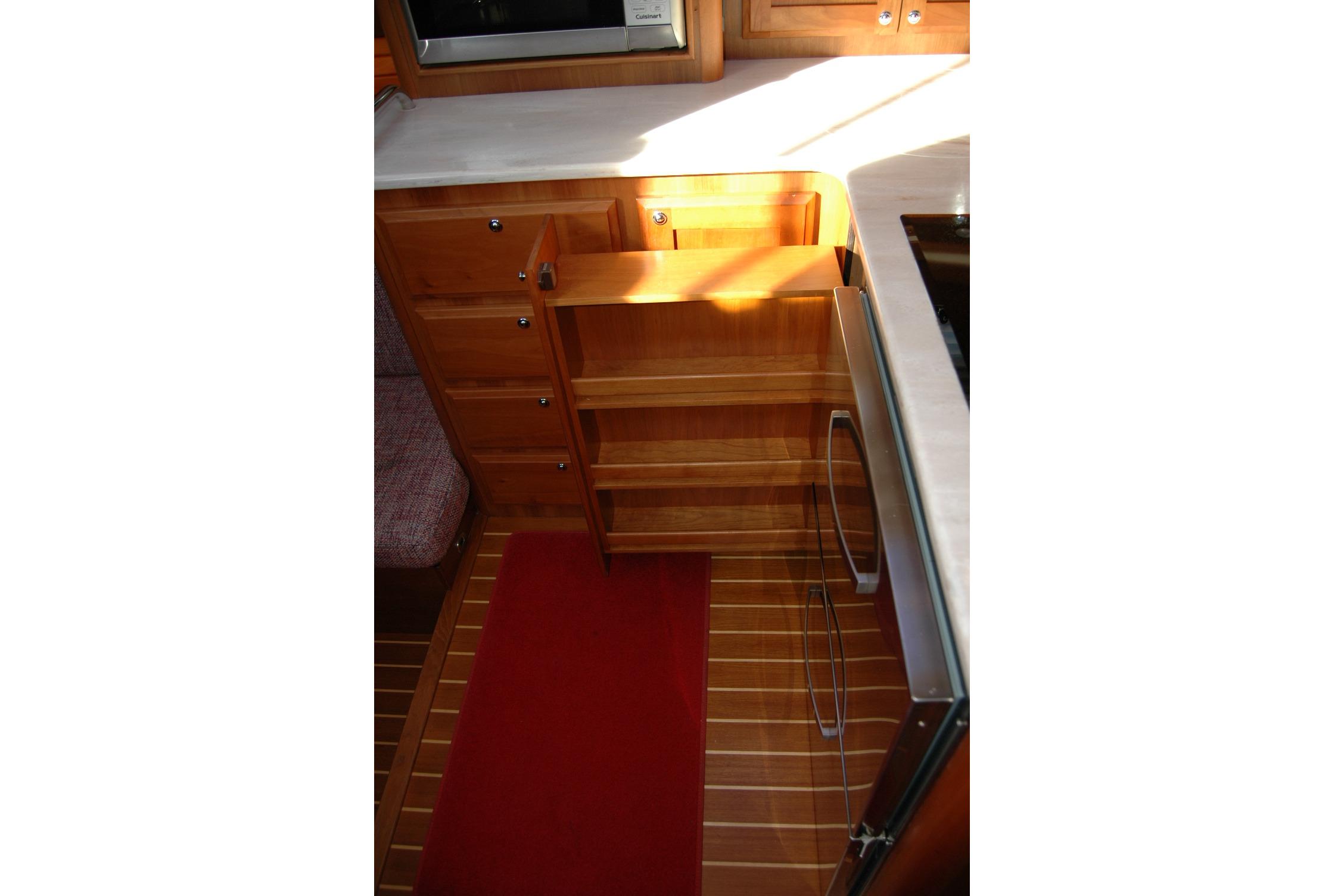 2019 Sabre 38 Salon Express kitchen with wooden cabinetry and pull-out shelves.