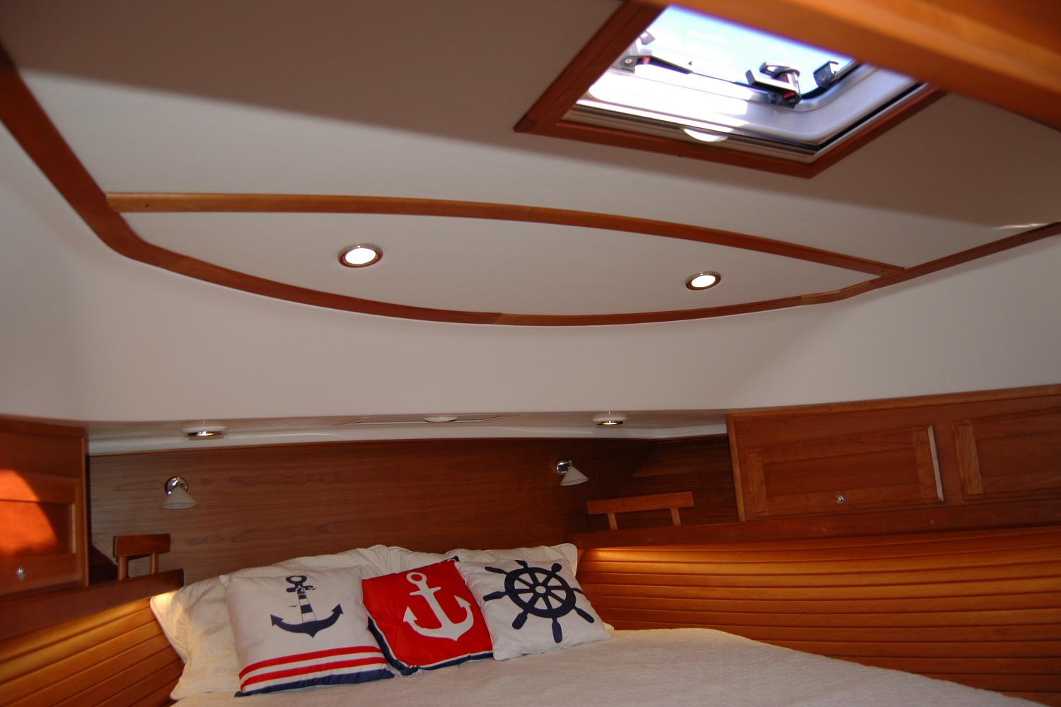 2019 Sabre 38 Salon Express cabin with nautical-themed pillows and wooden interior.