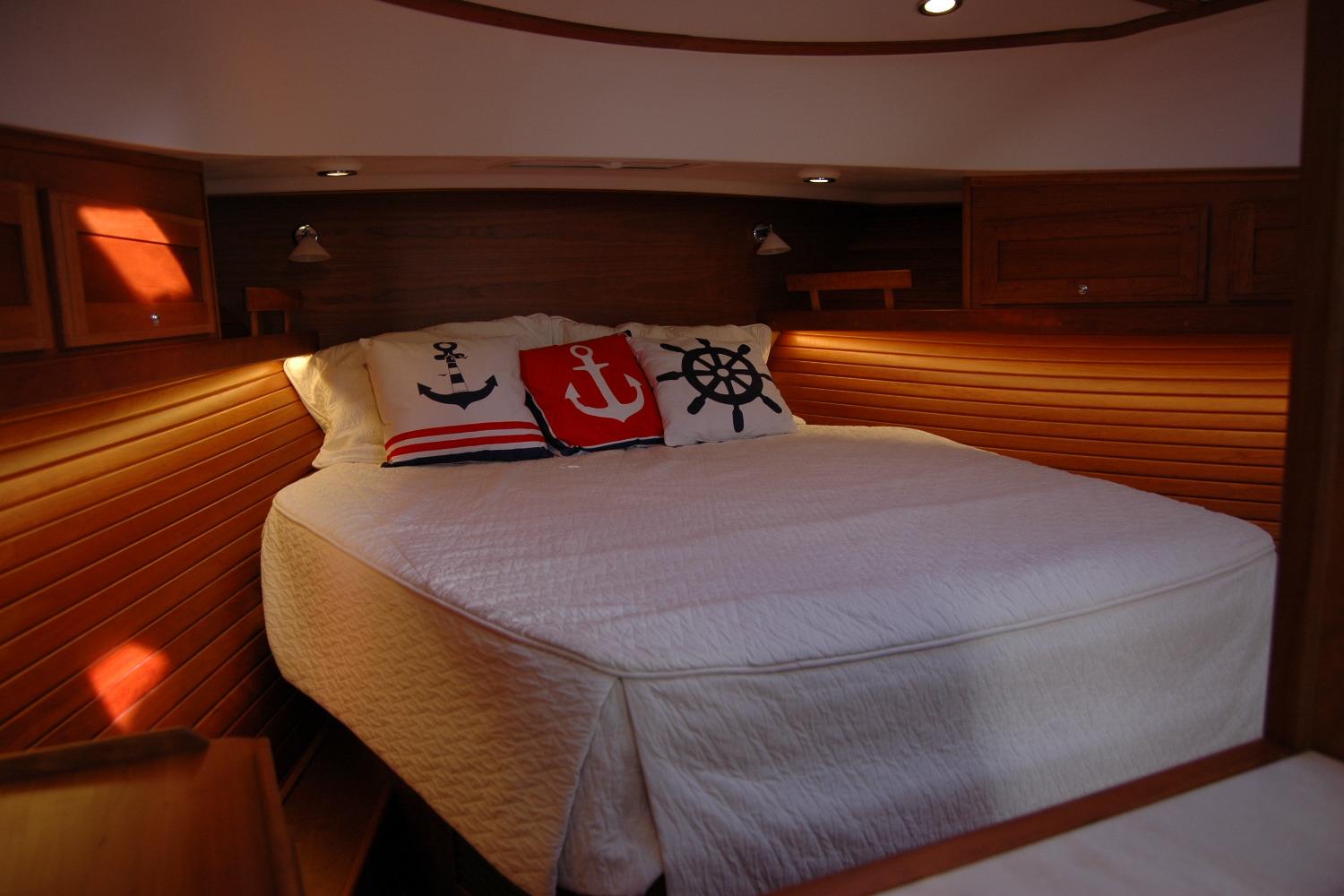 Cozy cabin bedroom in 2019 Sabre 38 Salon Express with nautical-themed pillows.