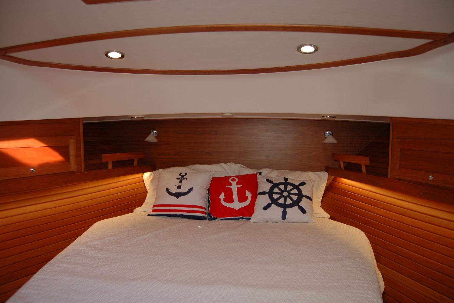 Cozy cabin bedroom in 2019 Sabre 38 Salon Express with nautical-themed pillows.
