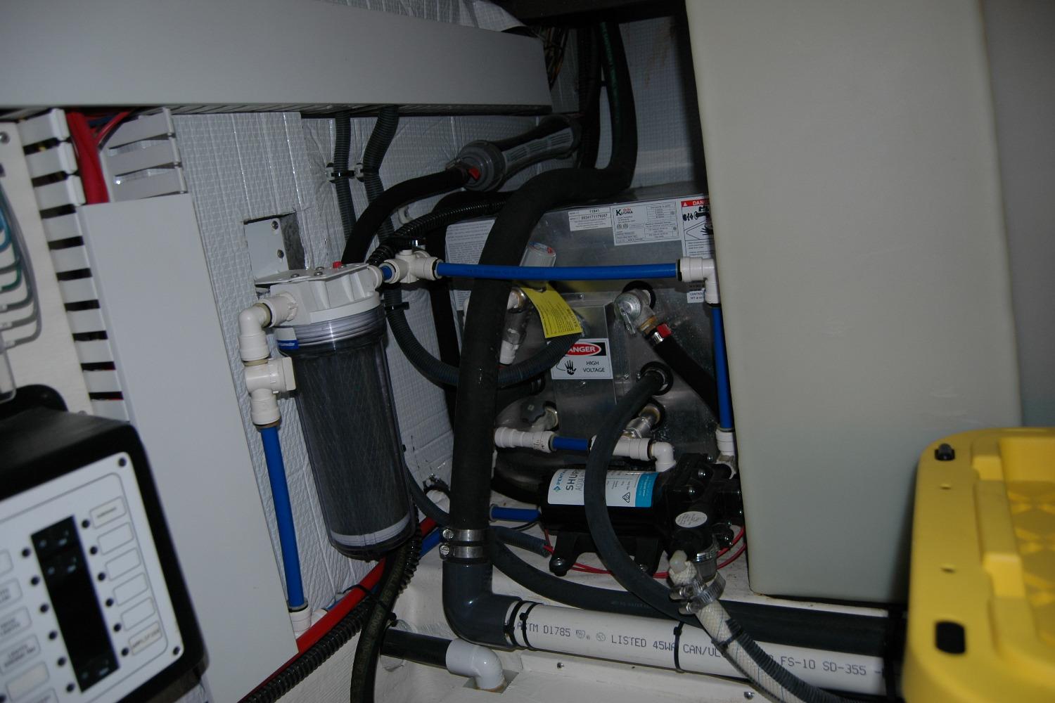 Engine room of 2019 Sabre 38 Salon Express with complex piping and filtration system.