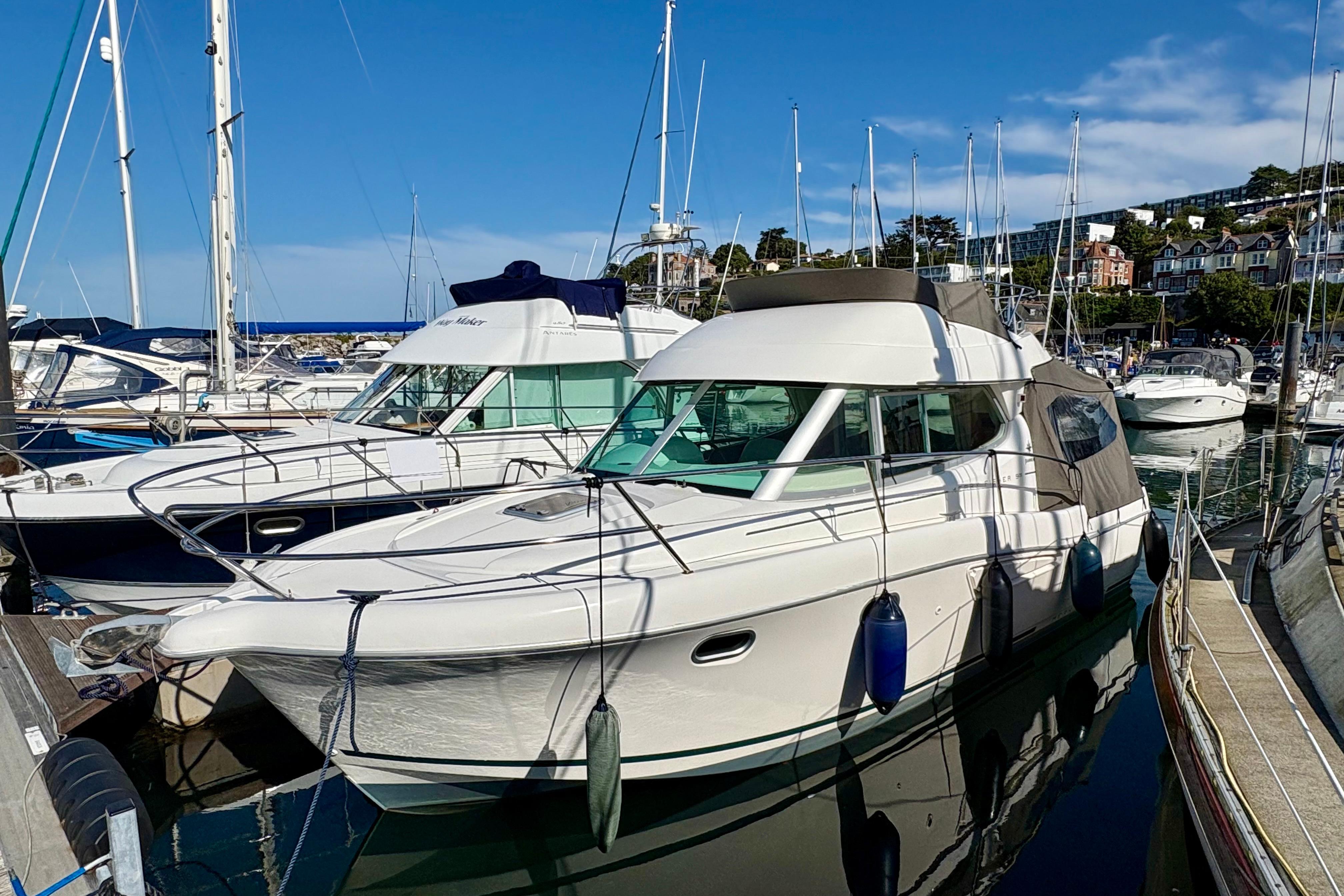 2008 Jeanneau Merry Fisher 925 docked in a marina under clear blue skies.
