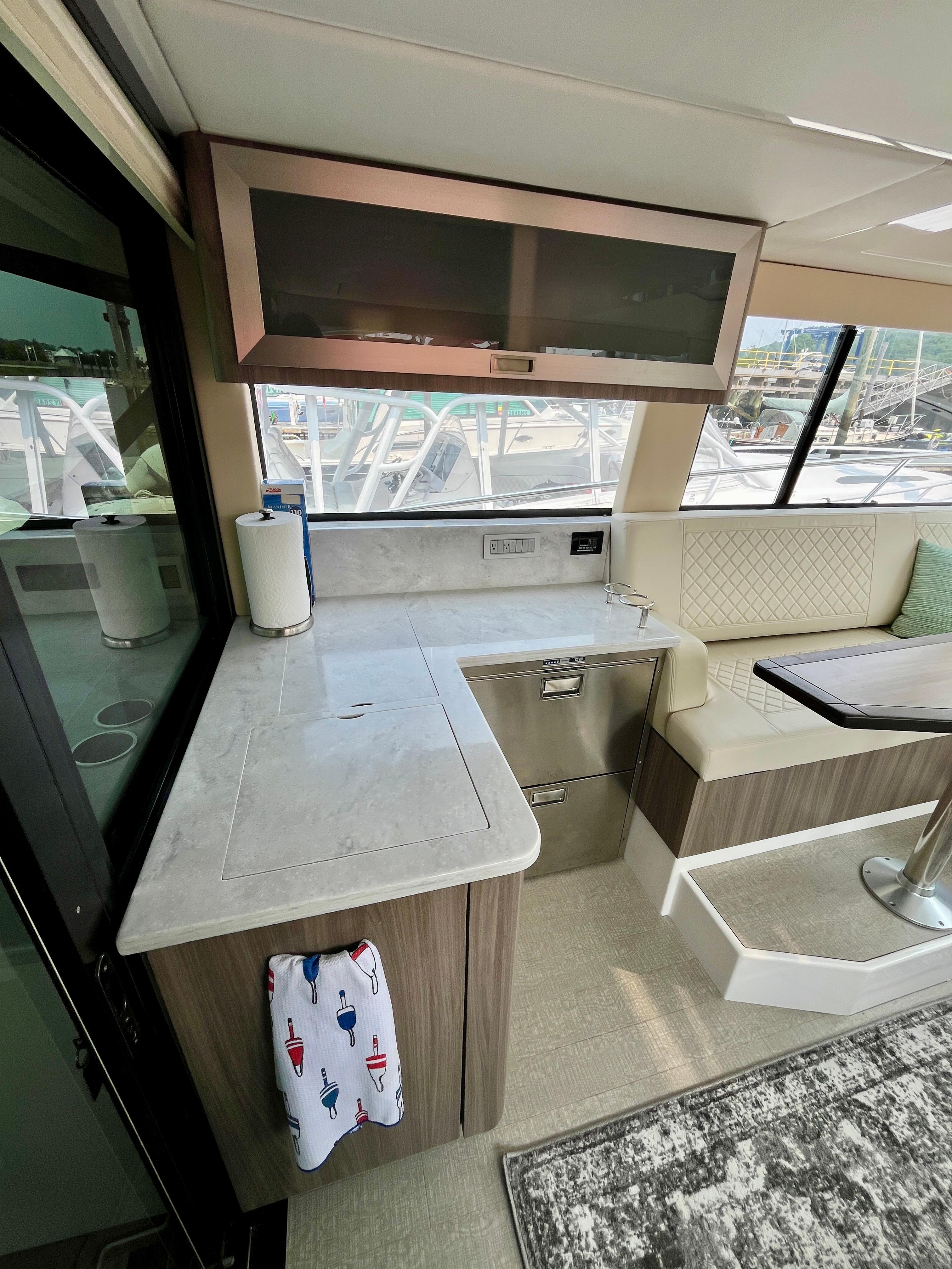 Interior of 2022 Regal 38 XO yacht with modern kitchen and seating area.