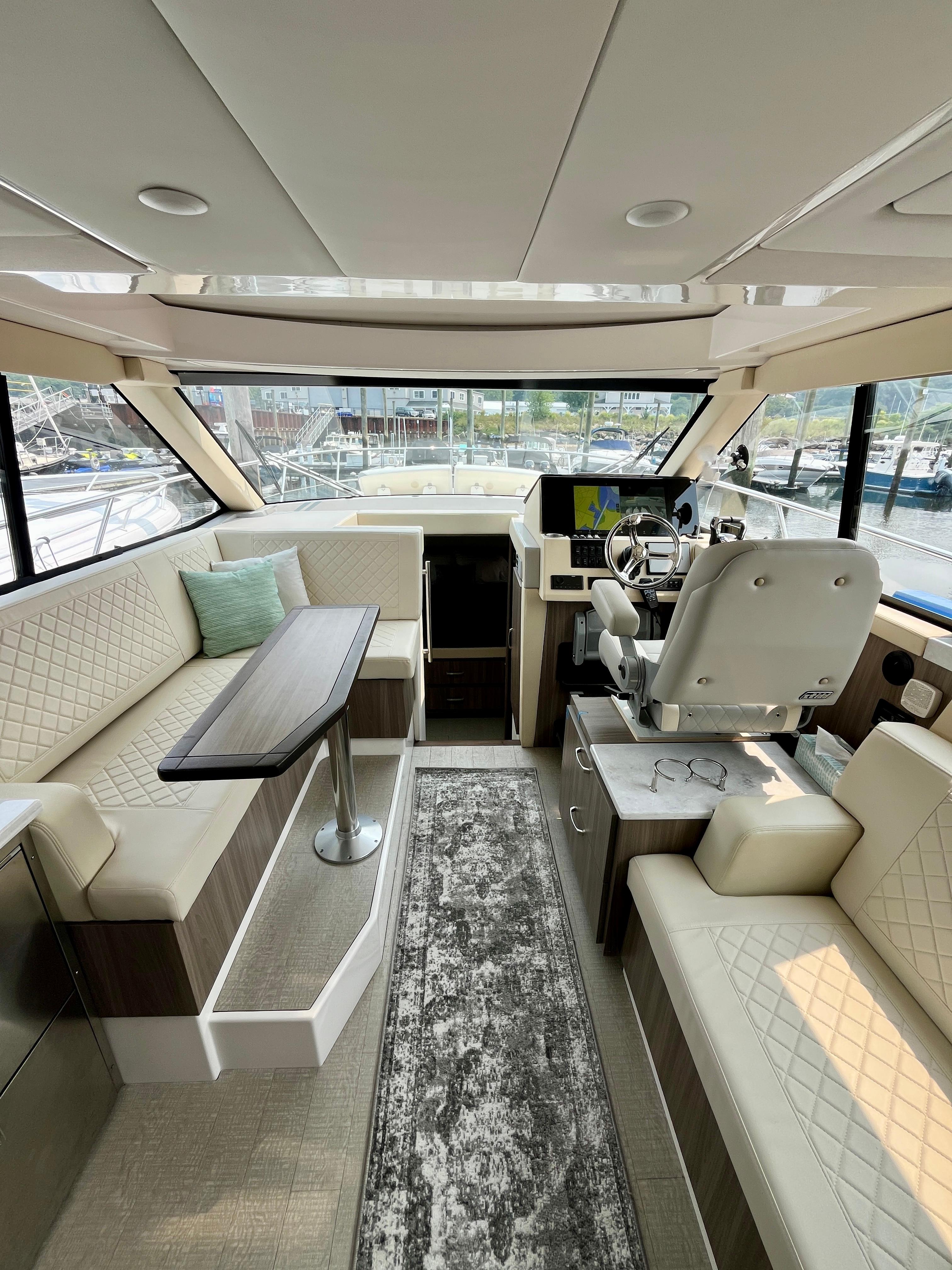 Luxurious interior of 2022 Regal 38 XO yacht with plush seating and modern helm.