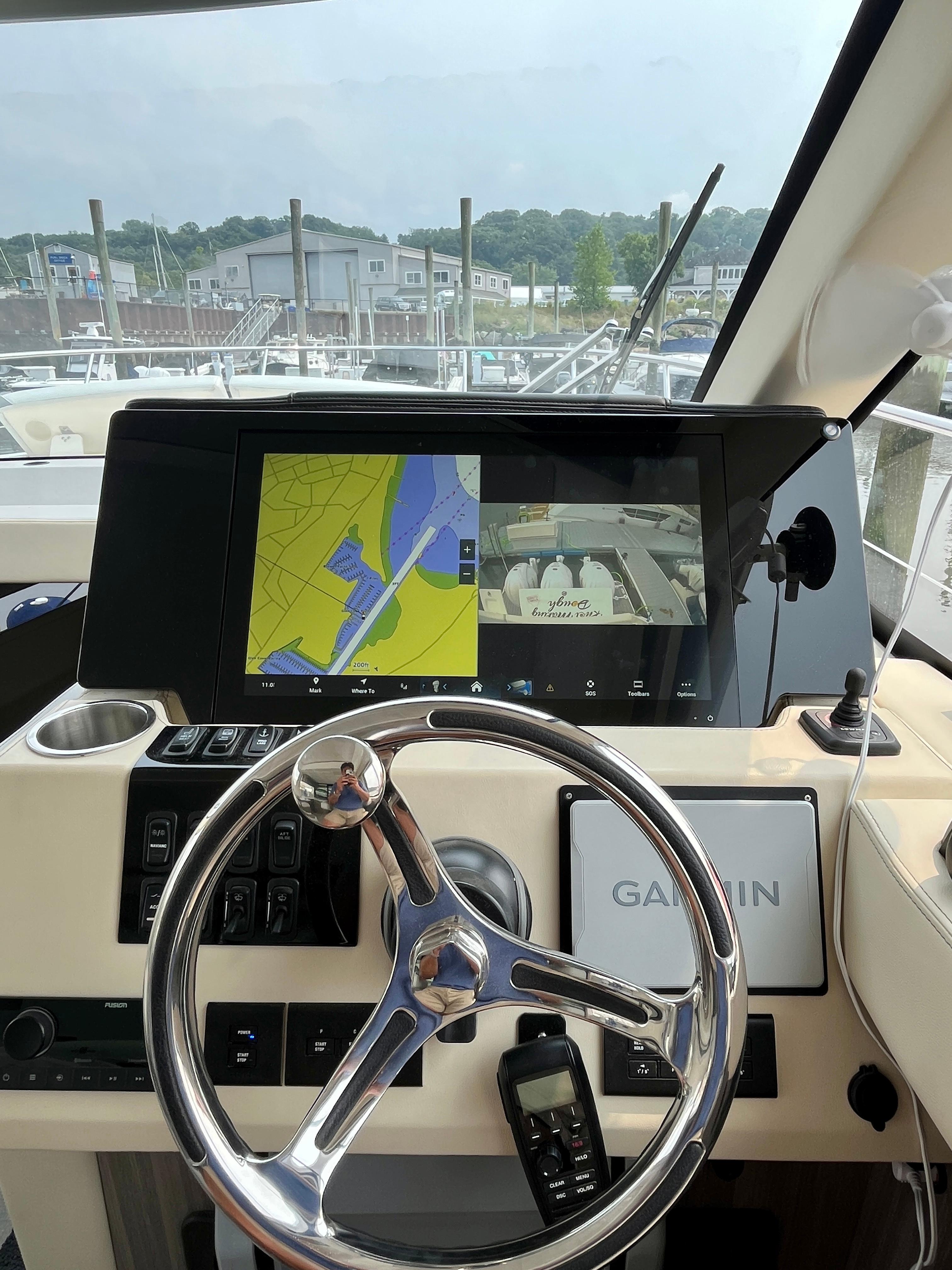 Helm of 2022 Regal 38 XO yacht with Garmin navigation display and steering wheel.