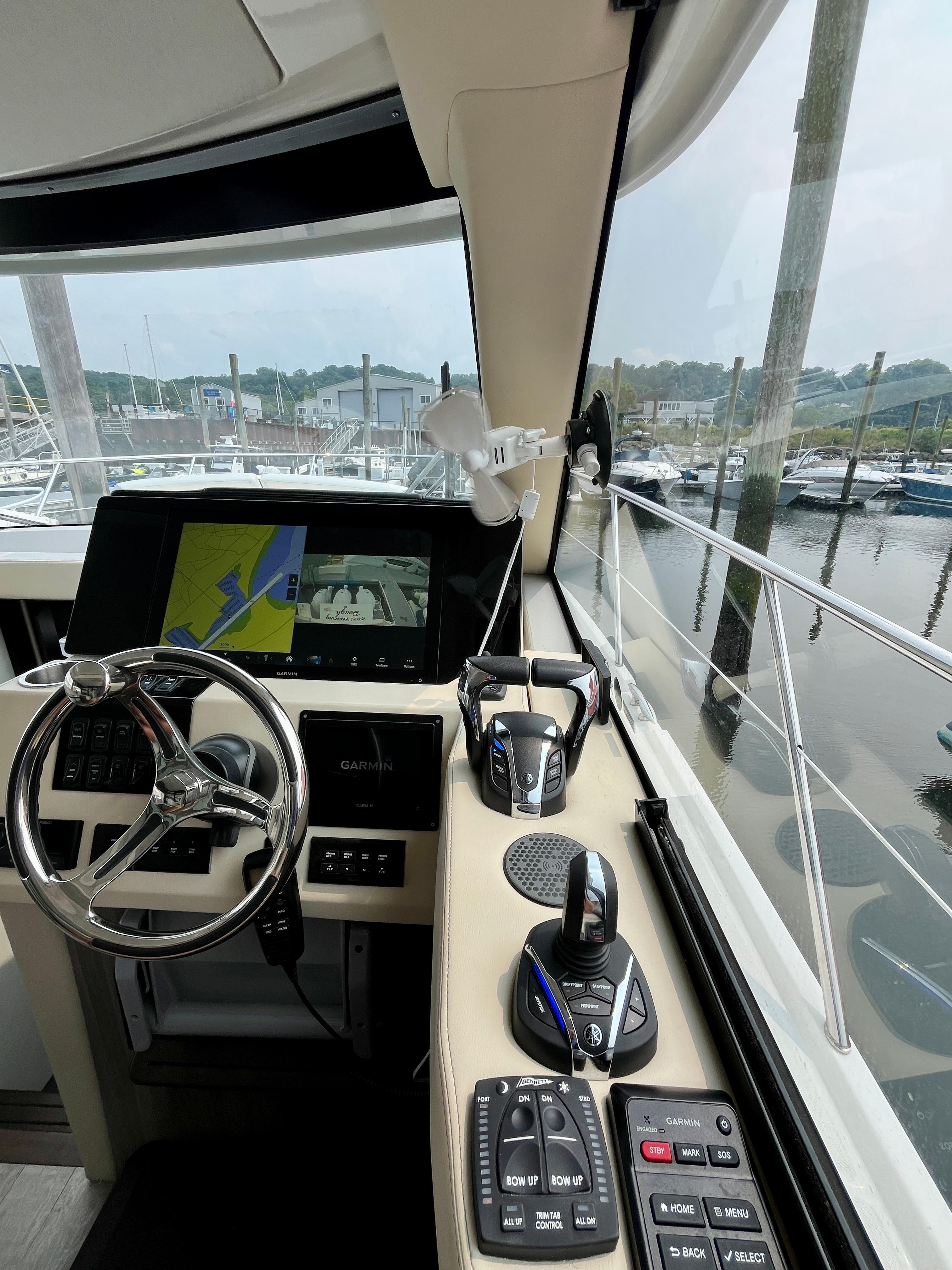 2022 Regal 38 XO yacht cockpit with navigation controls and marina view.
