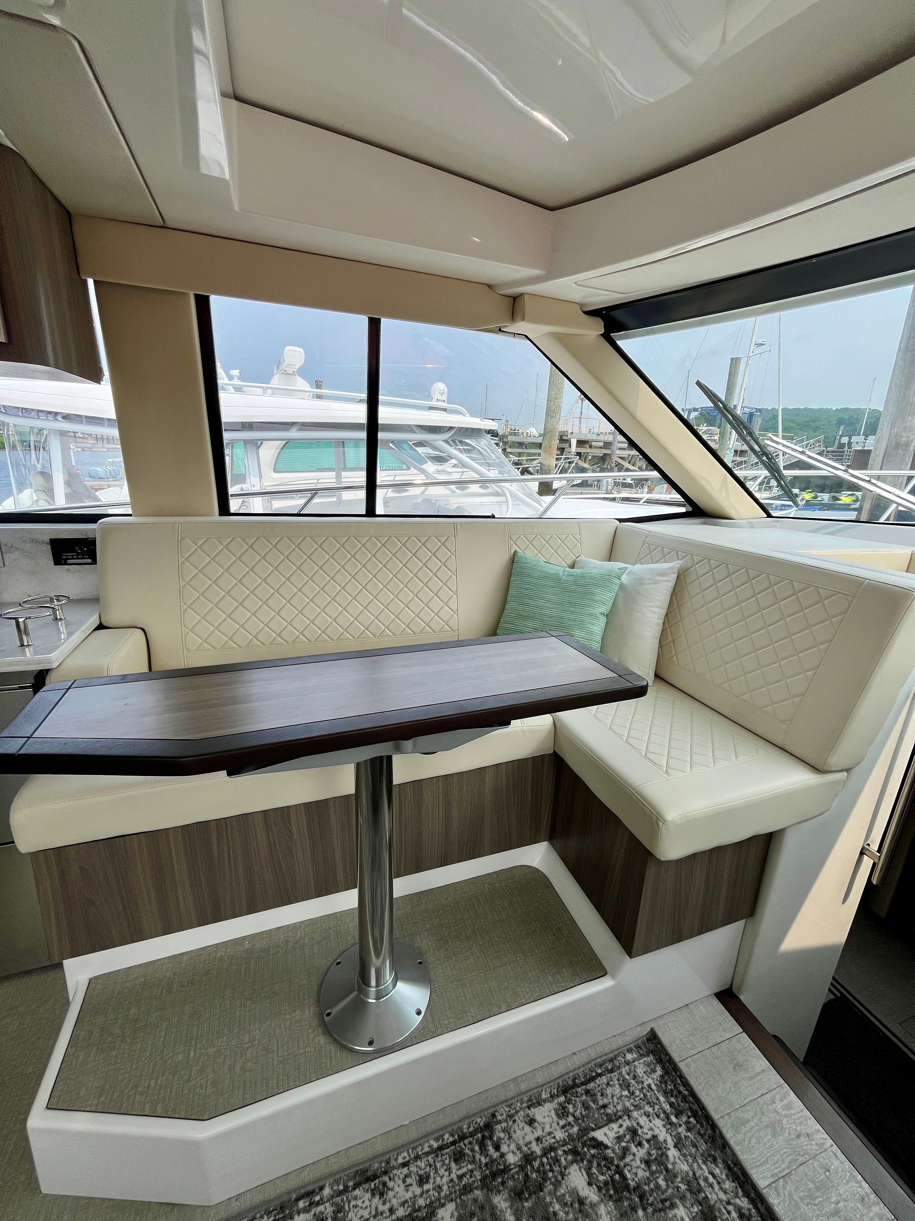 Luxurious interior of 2022 Regal 38 XO yacht with elegant seating and table.