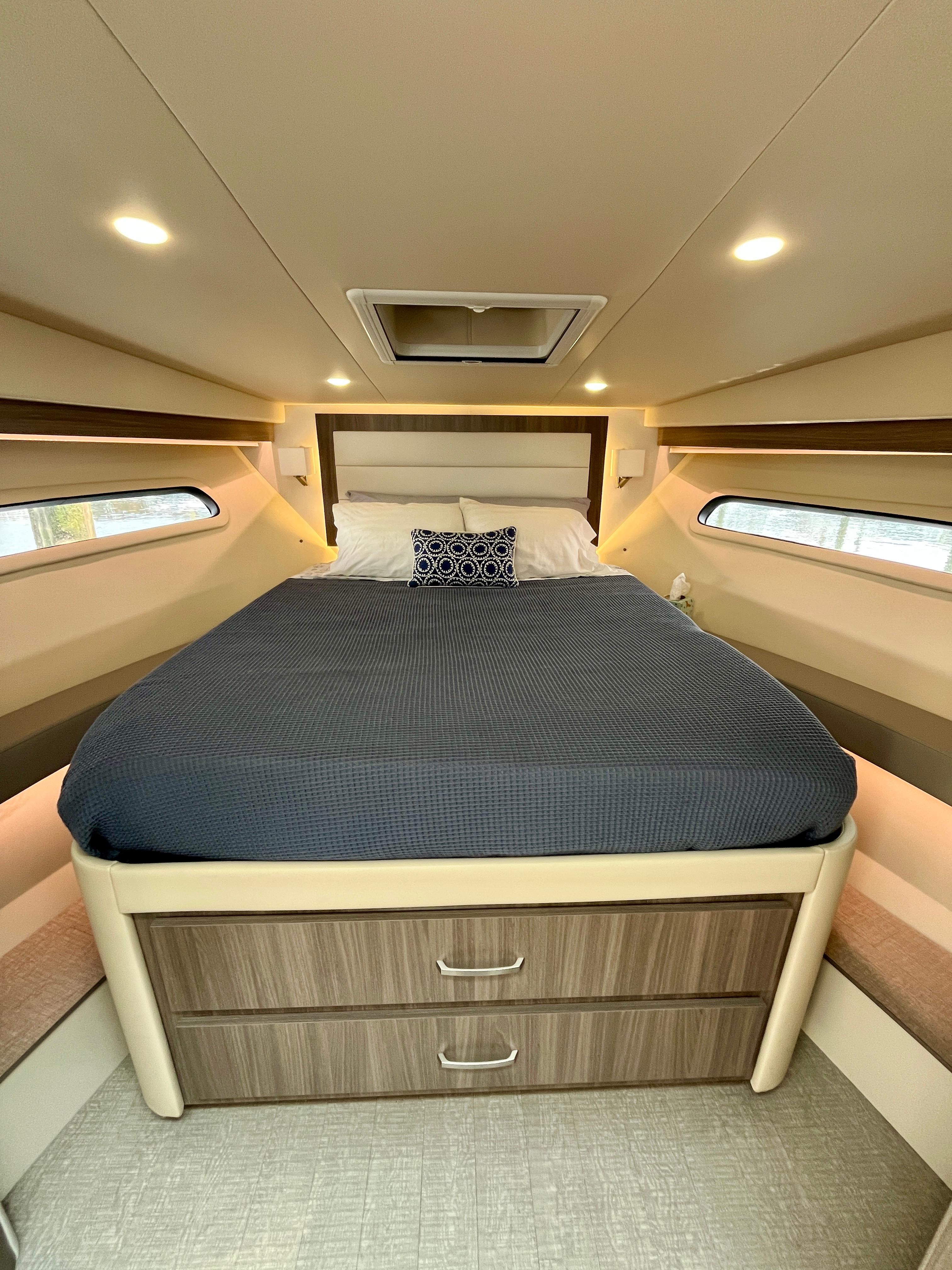 Luxurious cabin interior of 2022 Regal 38 XO yacht with cozy bed and modern design.