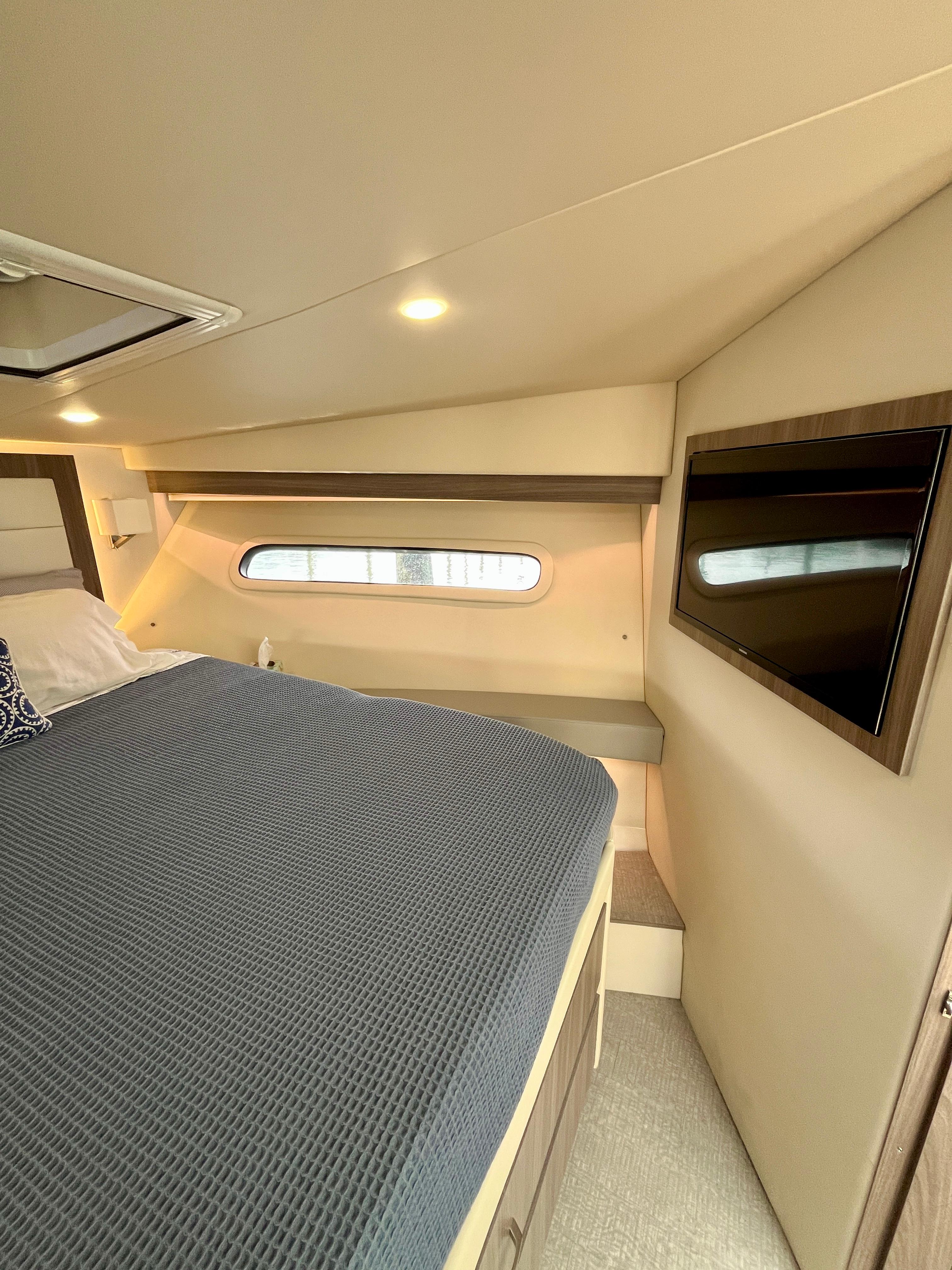 Luxurious cabin interior of 2022 Regal 38 XO yacht with bed and window.