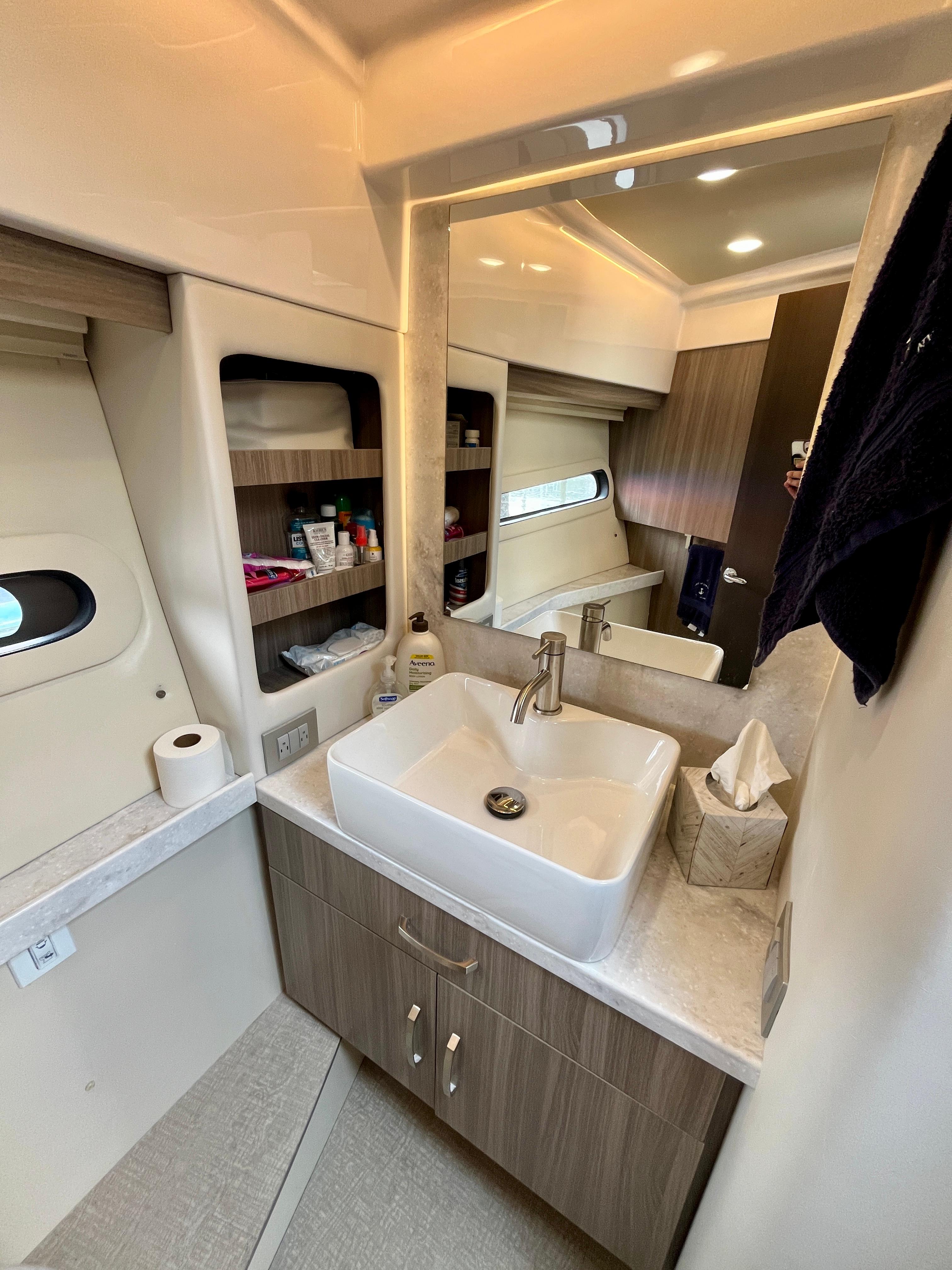 Luxurious bathroom interior of 2022 Regal 38 XO yacht with modern sink and storage.
