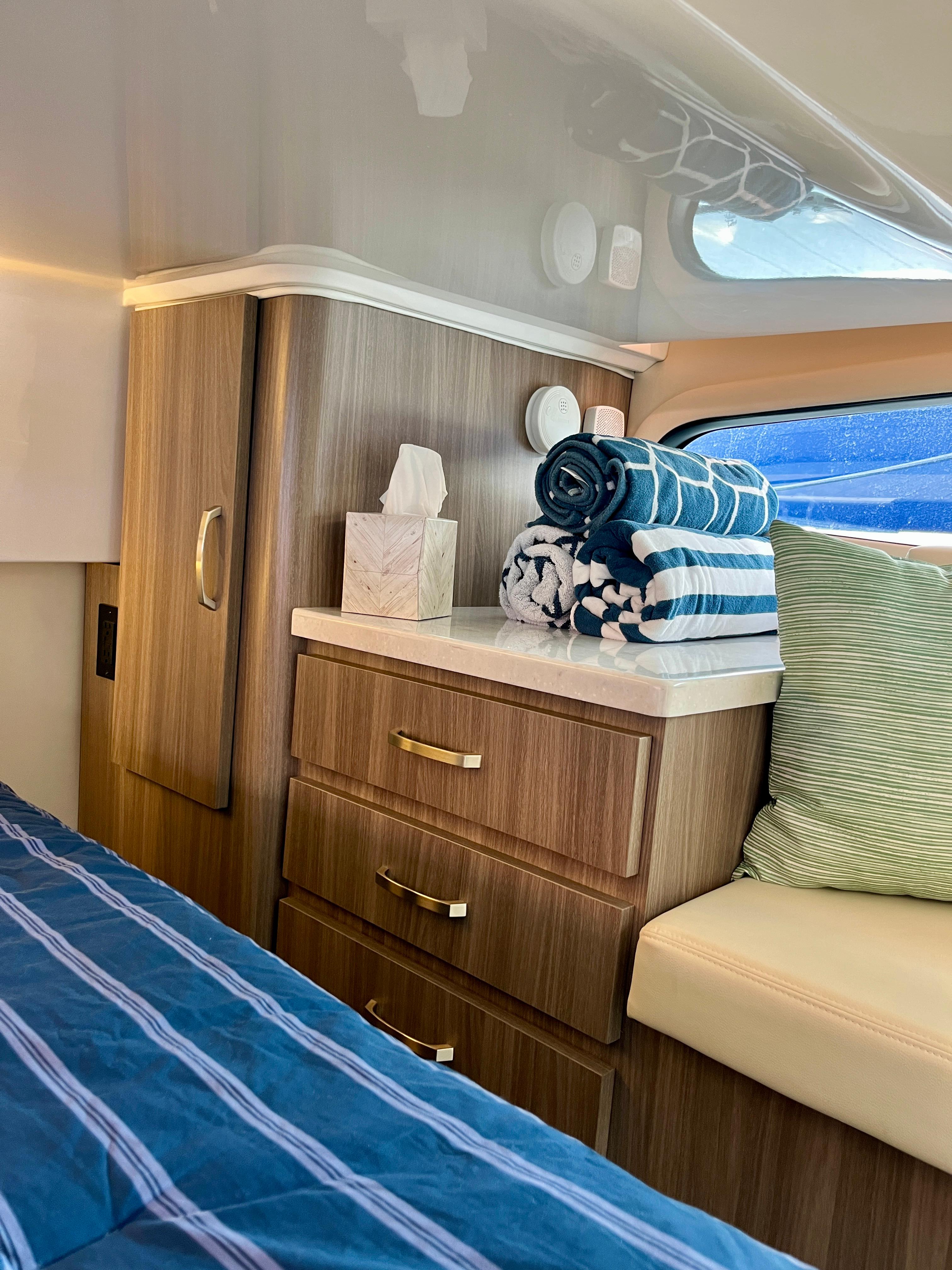 Interior of 2022 Regal 38 XO yacht with wooden cabinetry and striped towels.