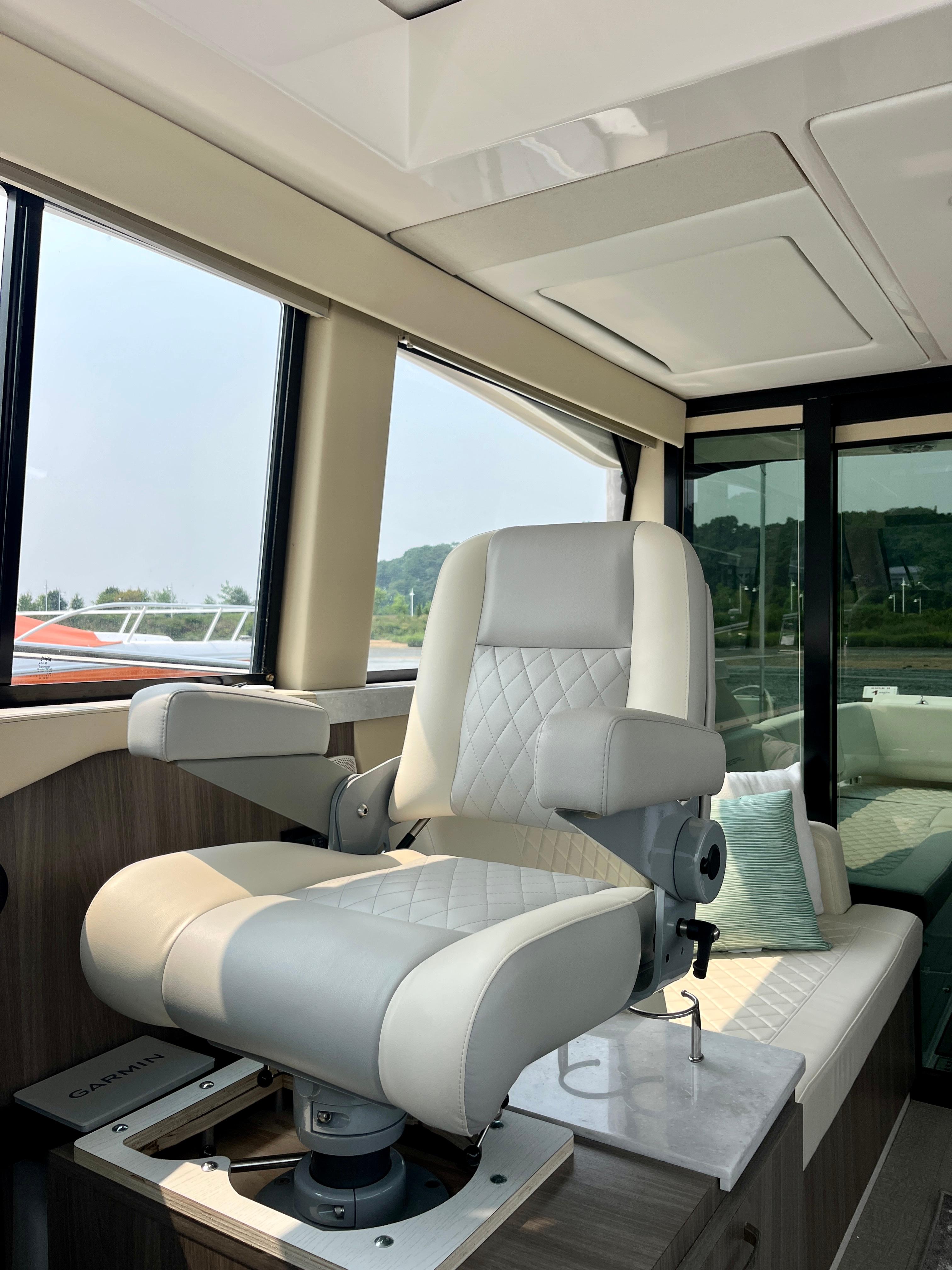Luxurious captainu0027s chair inside 2022 Regal 38 XO yacht, featuring elegant design and comfort.
