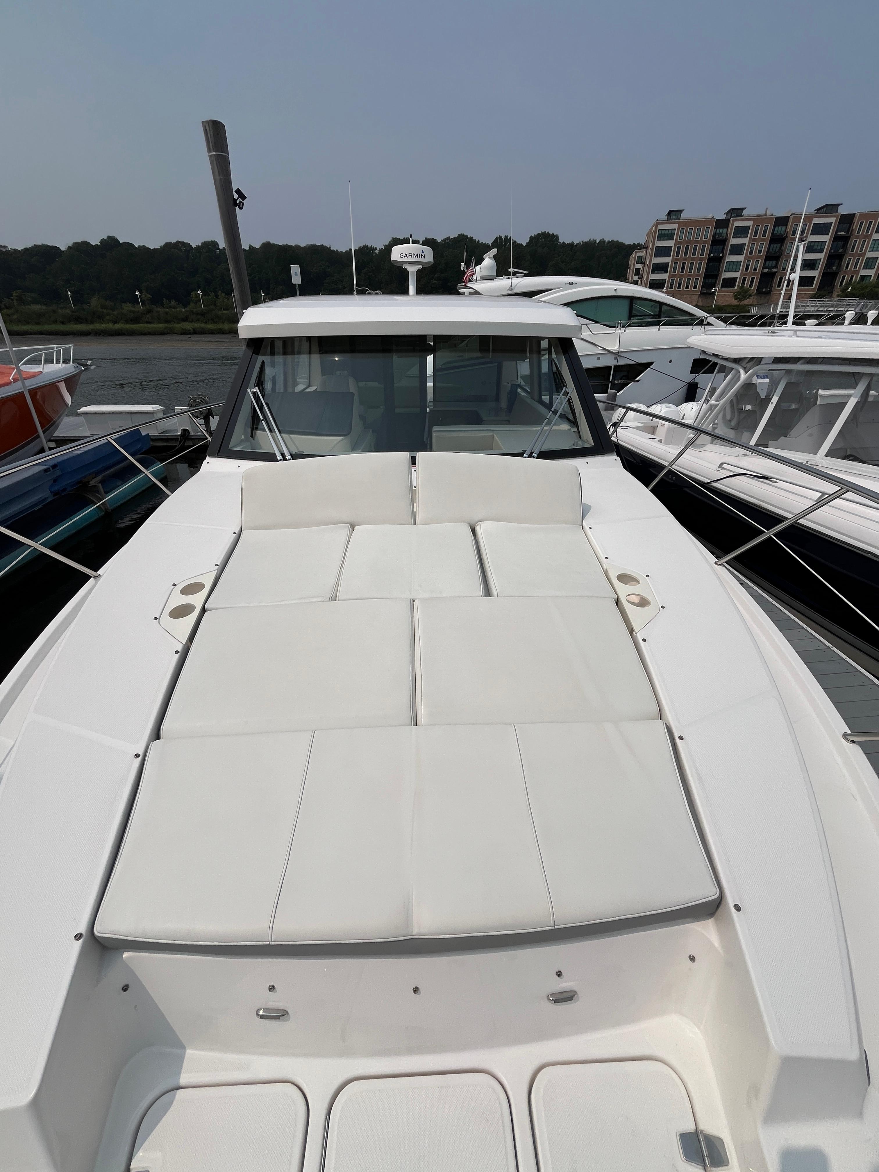 2022 Regal 38 XO yacht with spacious sunbathing deck, docked at marina.