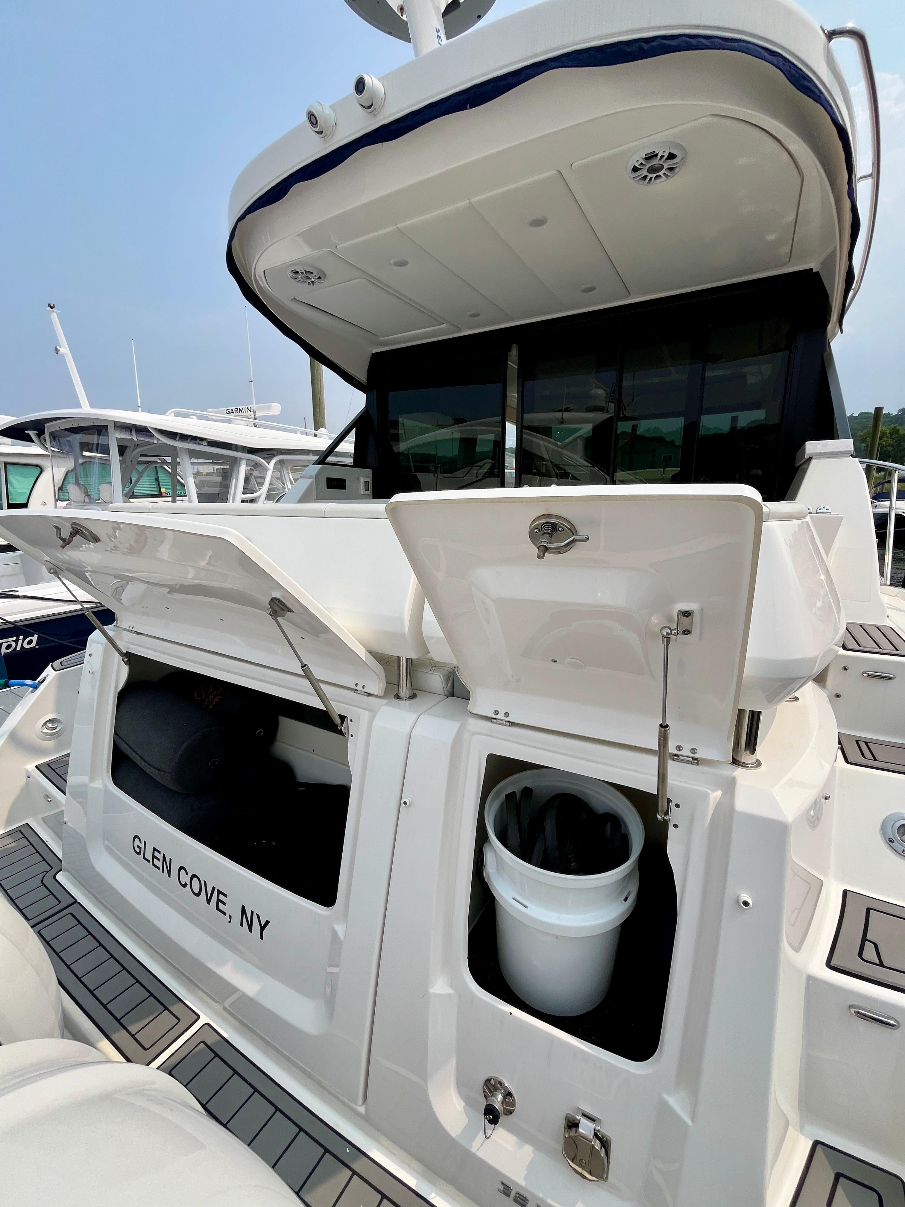 2022 Regal 38 XO yacht stern view with storage compartments open, docked in Glen Cove, NY.