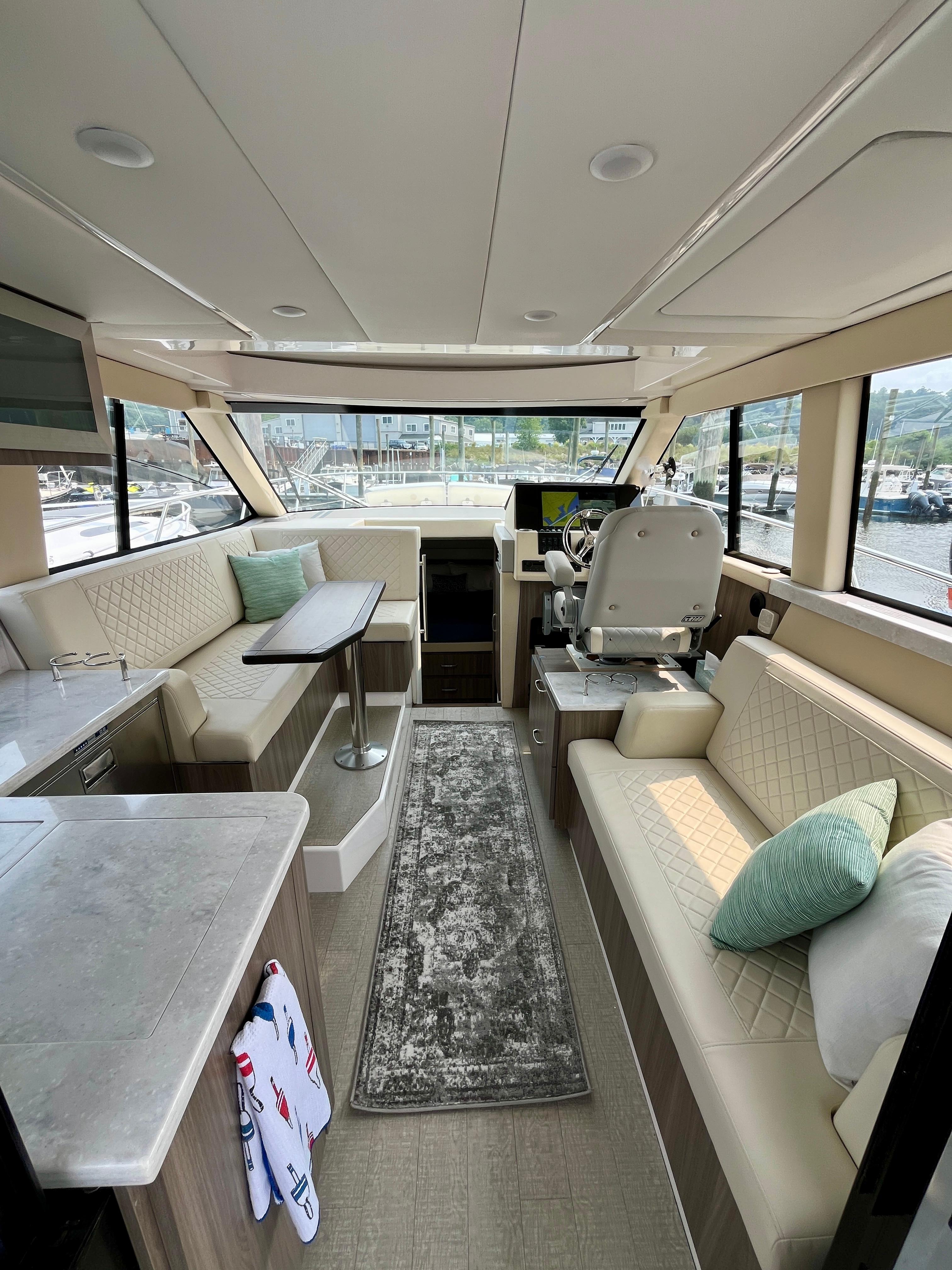 Luxurious interior of 2022 Regal 38 XO yacht with elegant seating and helm station.
