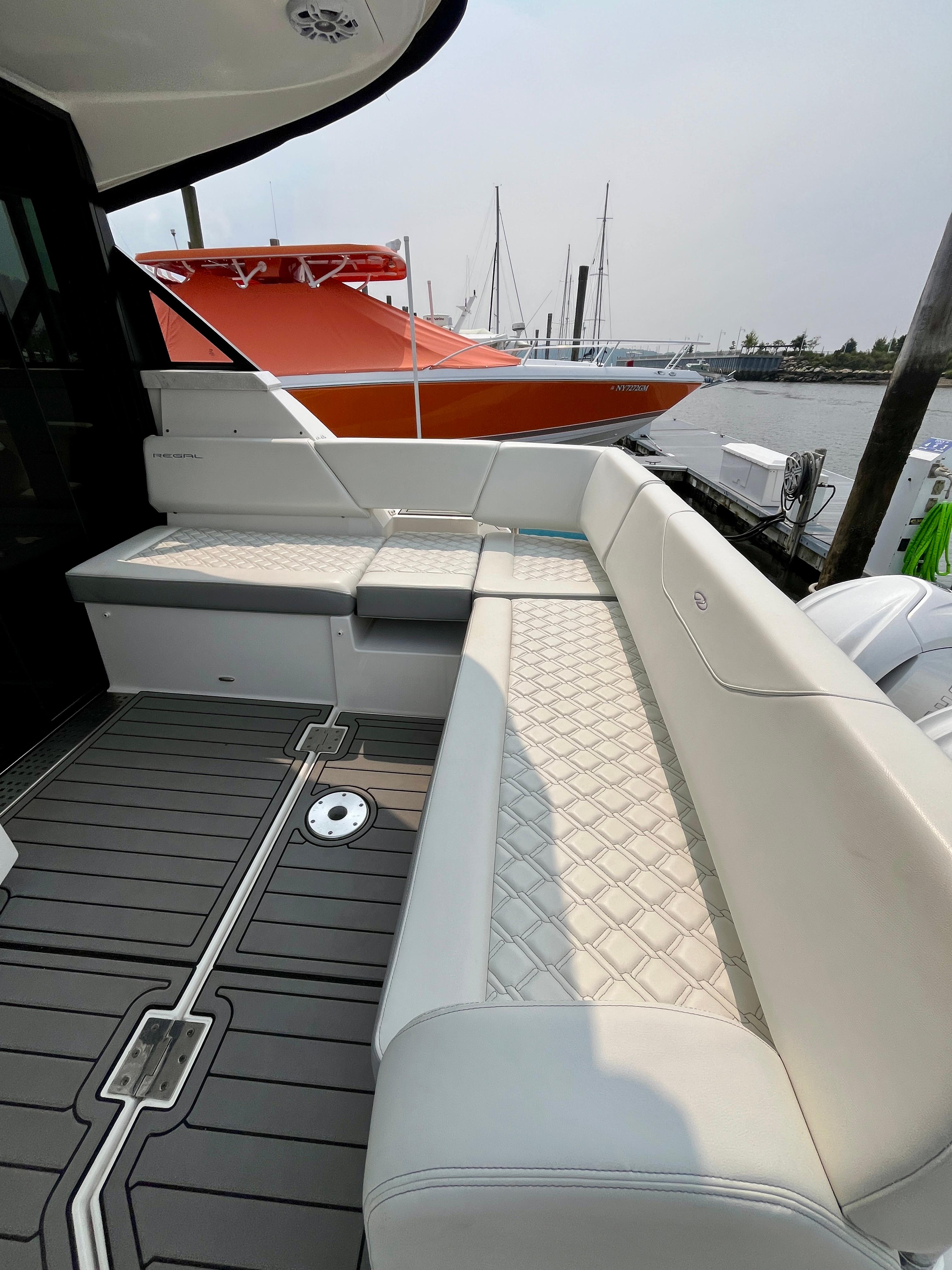 Luxurious seating on 2022 Regal 38 XO yacht with elegant design and waterfront view.