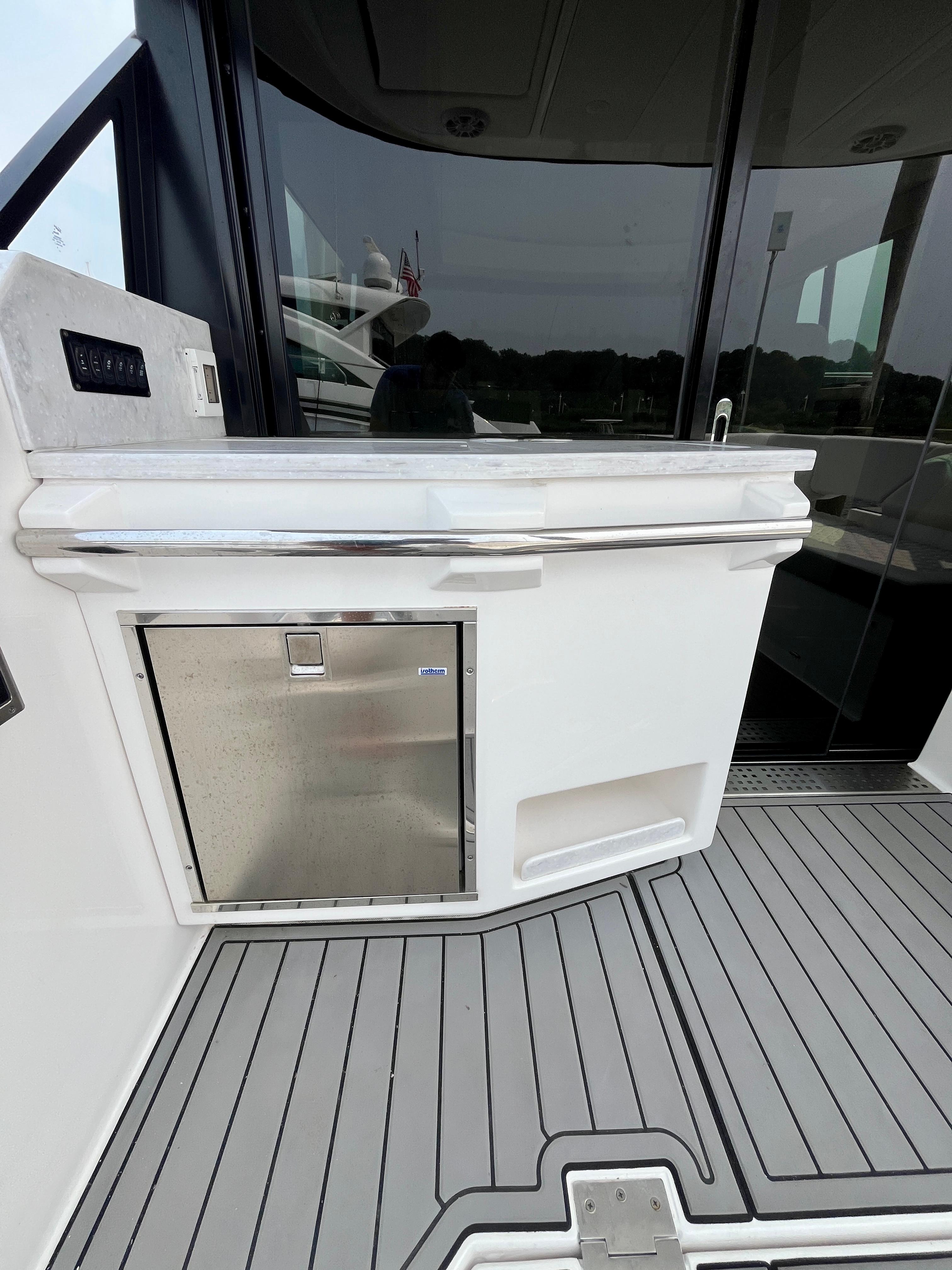 2022 Regal 38 XO yacht deck with stainless steel fridge and sleek design.
