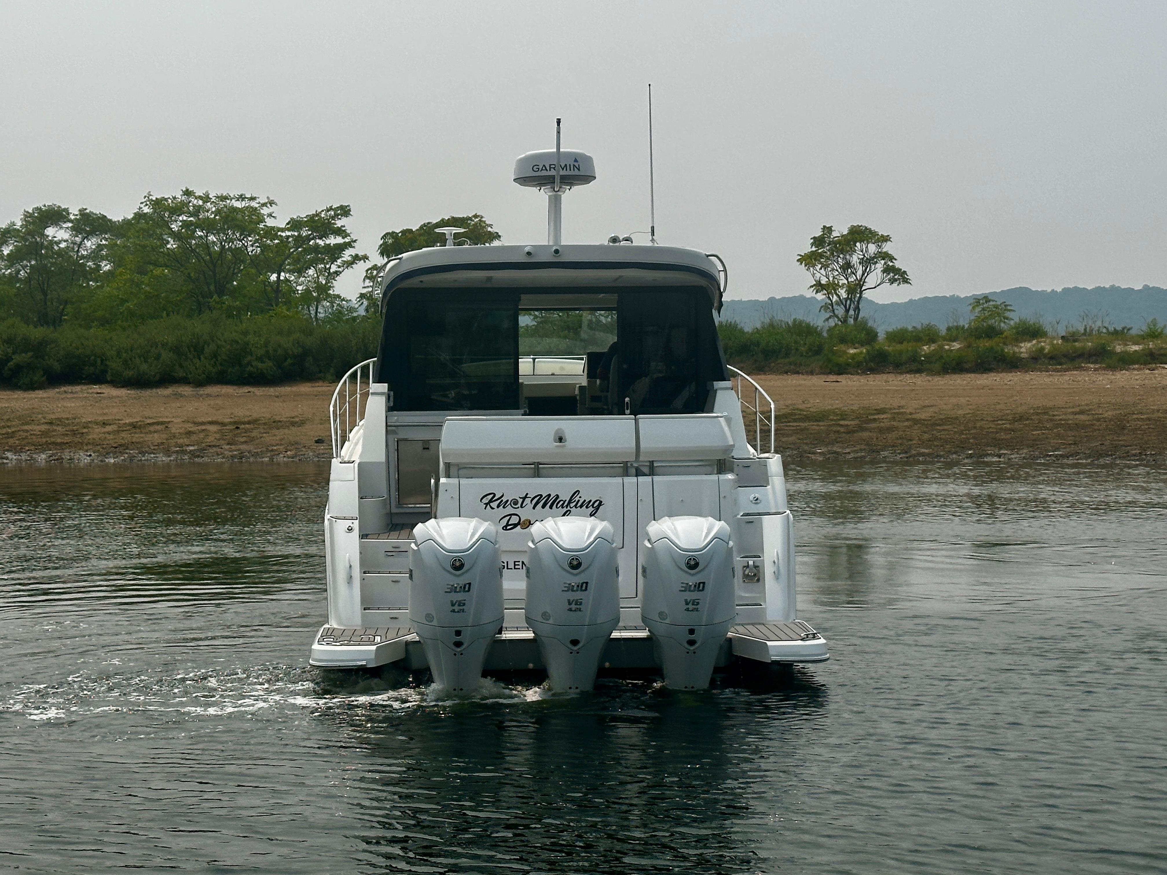 2022 Regal 38 XO boat with triple outboard engines on calm water.
