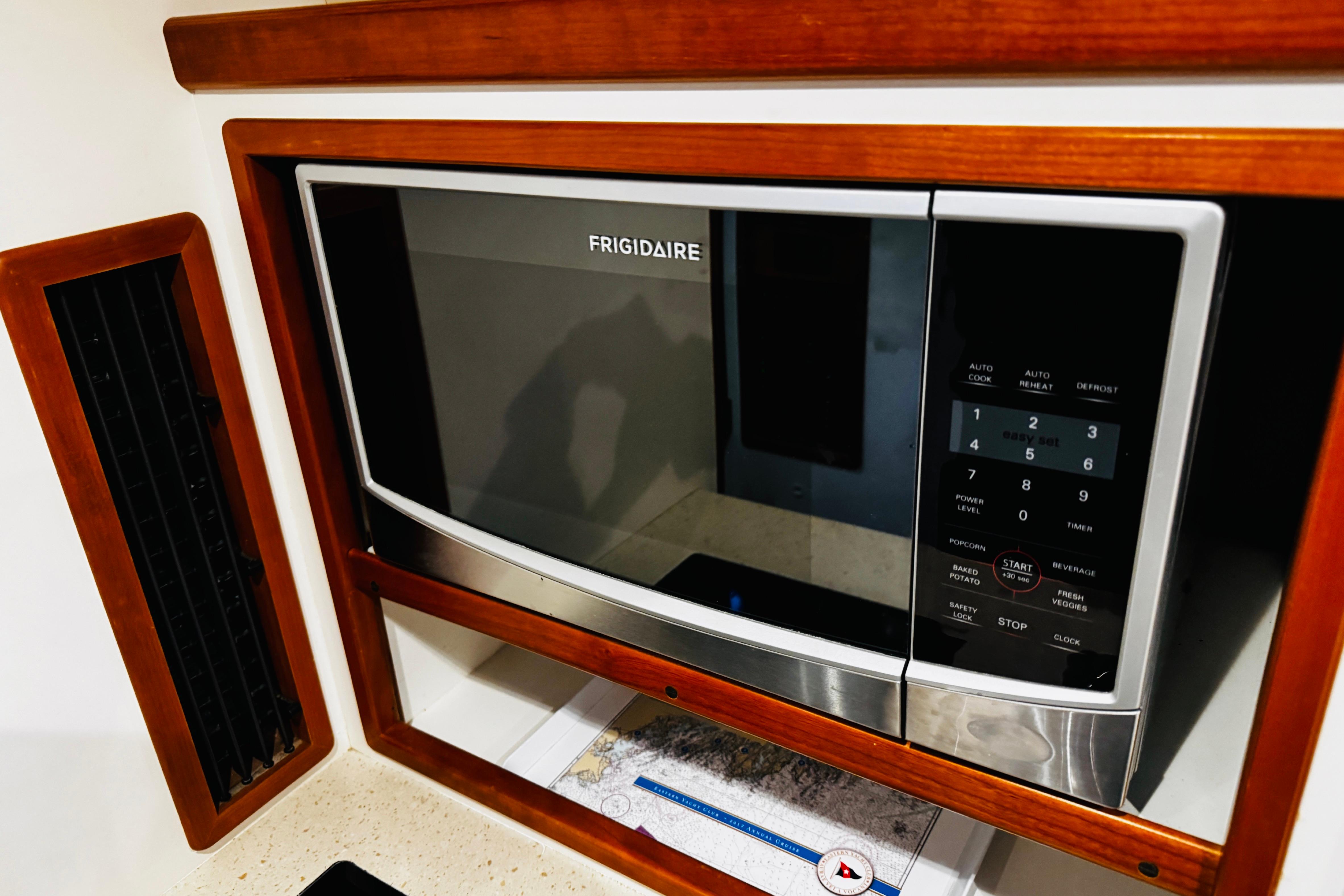 Frigidaire microwave in 2015 MJM 36z Express yacht kitchen, surrounded by wood paneling.
