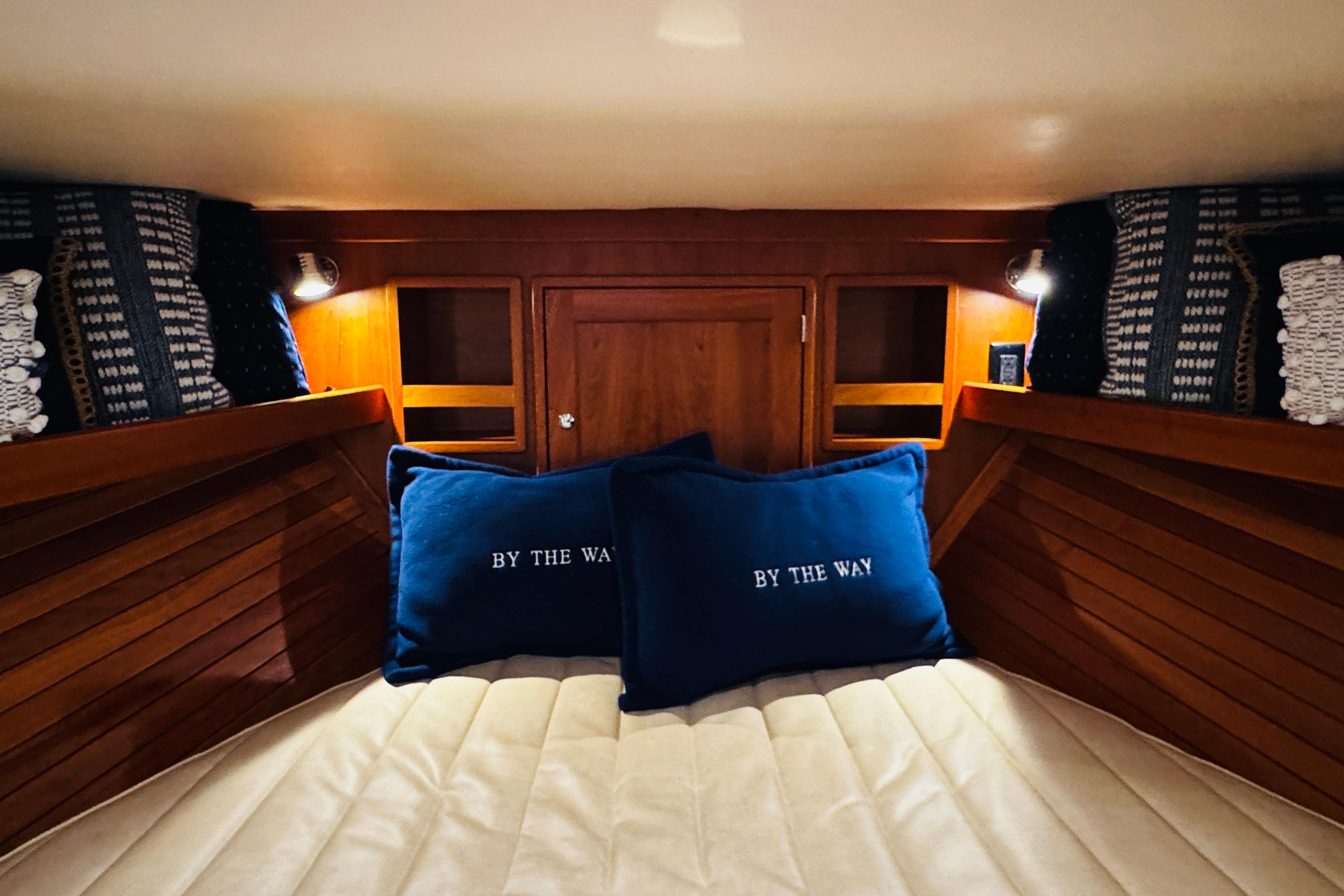 Cozy cabin interior of 2015 MJM 36z Express with blue pillows and wooden accents.