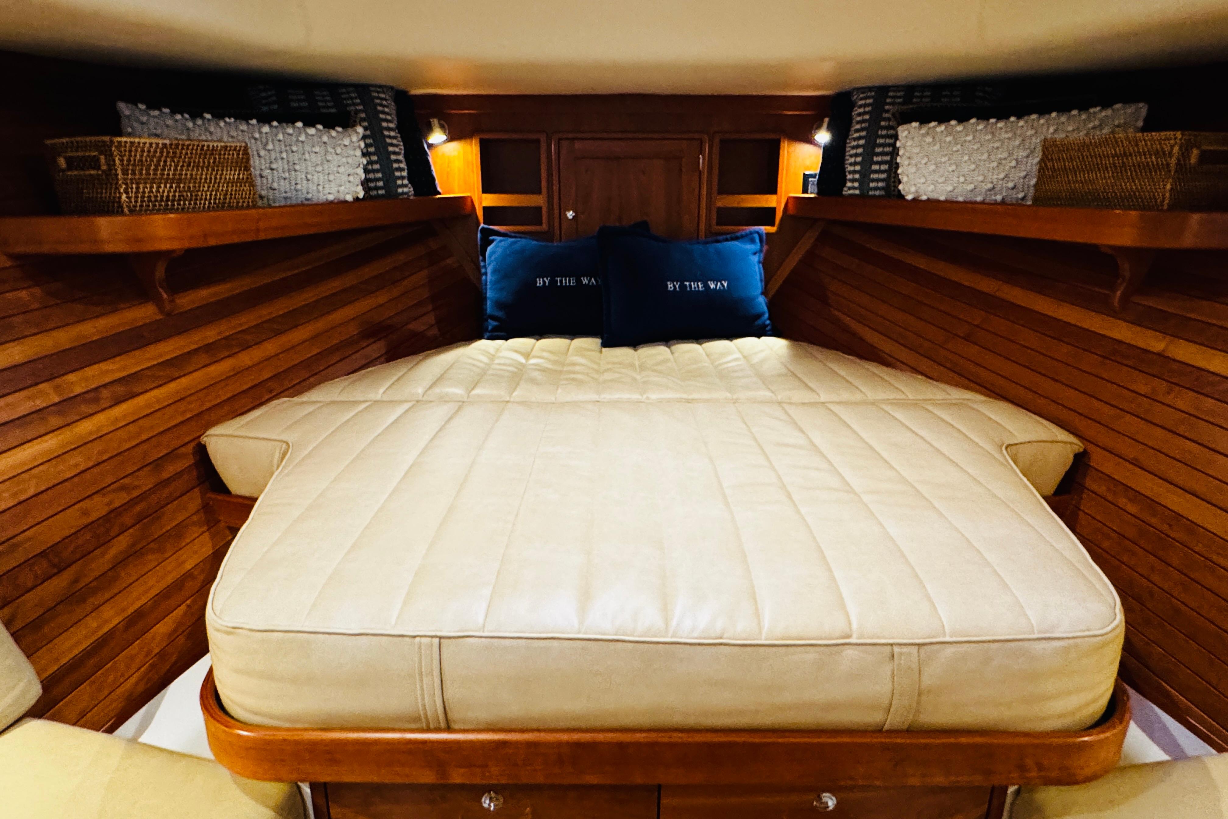 Luxurious cabin interior of 2015 MJM 36z Express with cozy bedding and wooden accents.