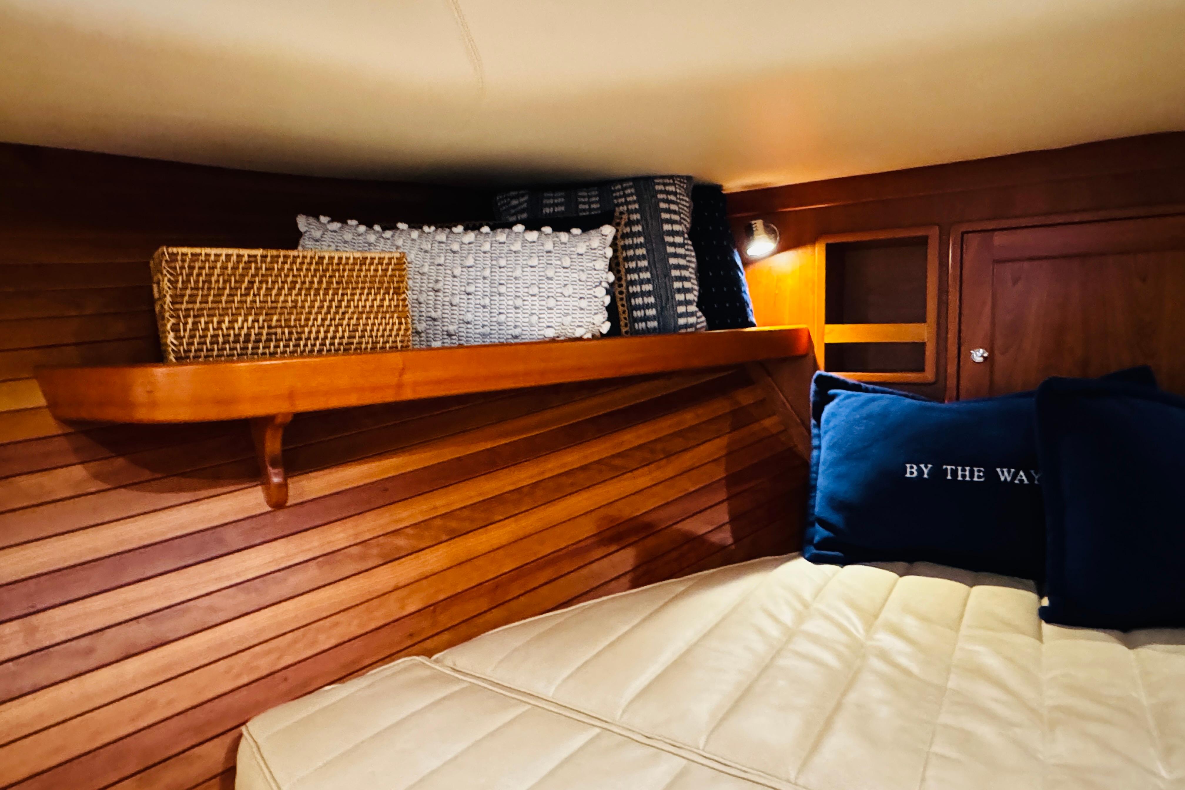 Cozy cabin interior of 2015 MJM 36z Express with wooden paneling and decorative pillows.