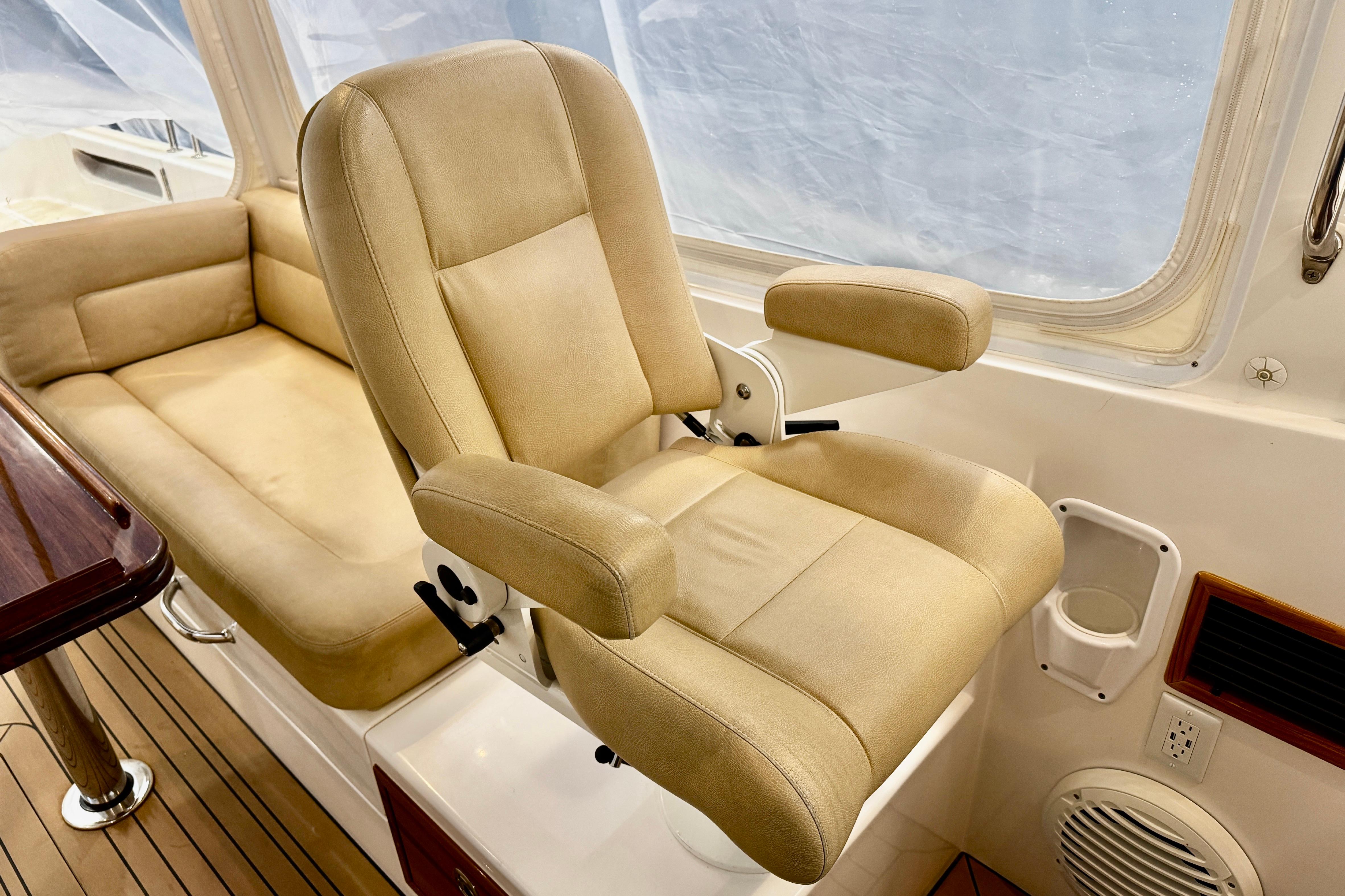 Captainu0027s chair and seating area on 2015 MJM 36z Express boat interior.